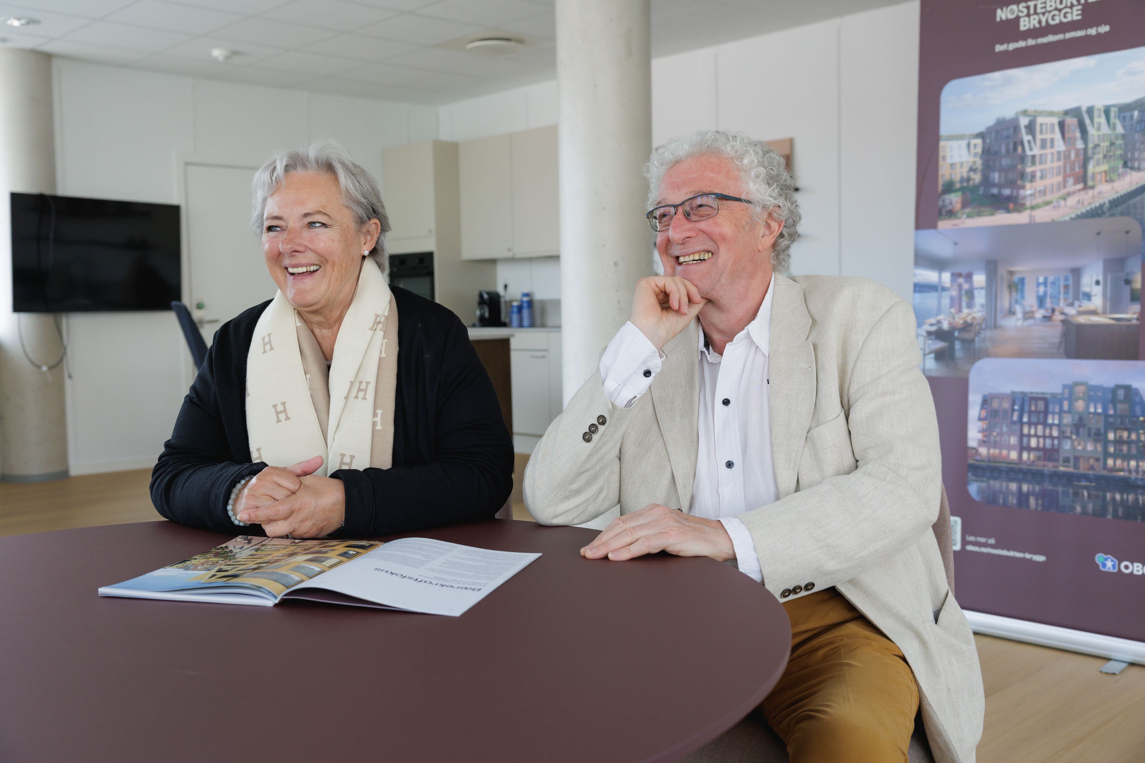 Edna og Øyvind sitter og smiler ved et bord