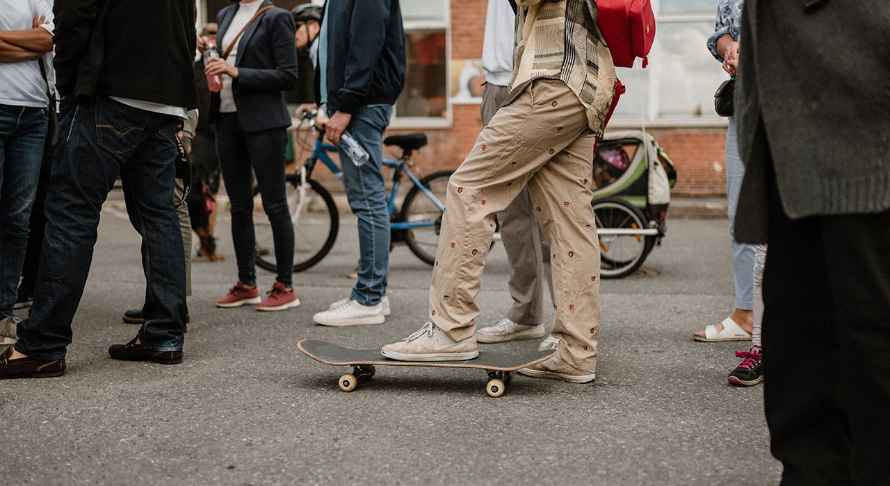 Bein på et skateboard i en gjeng av mennesker.