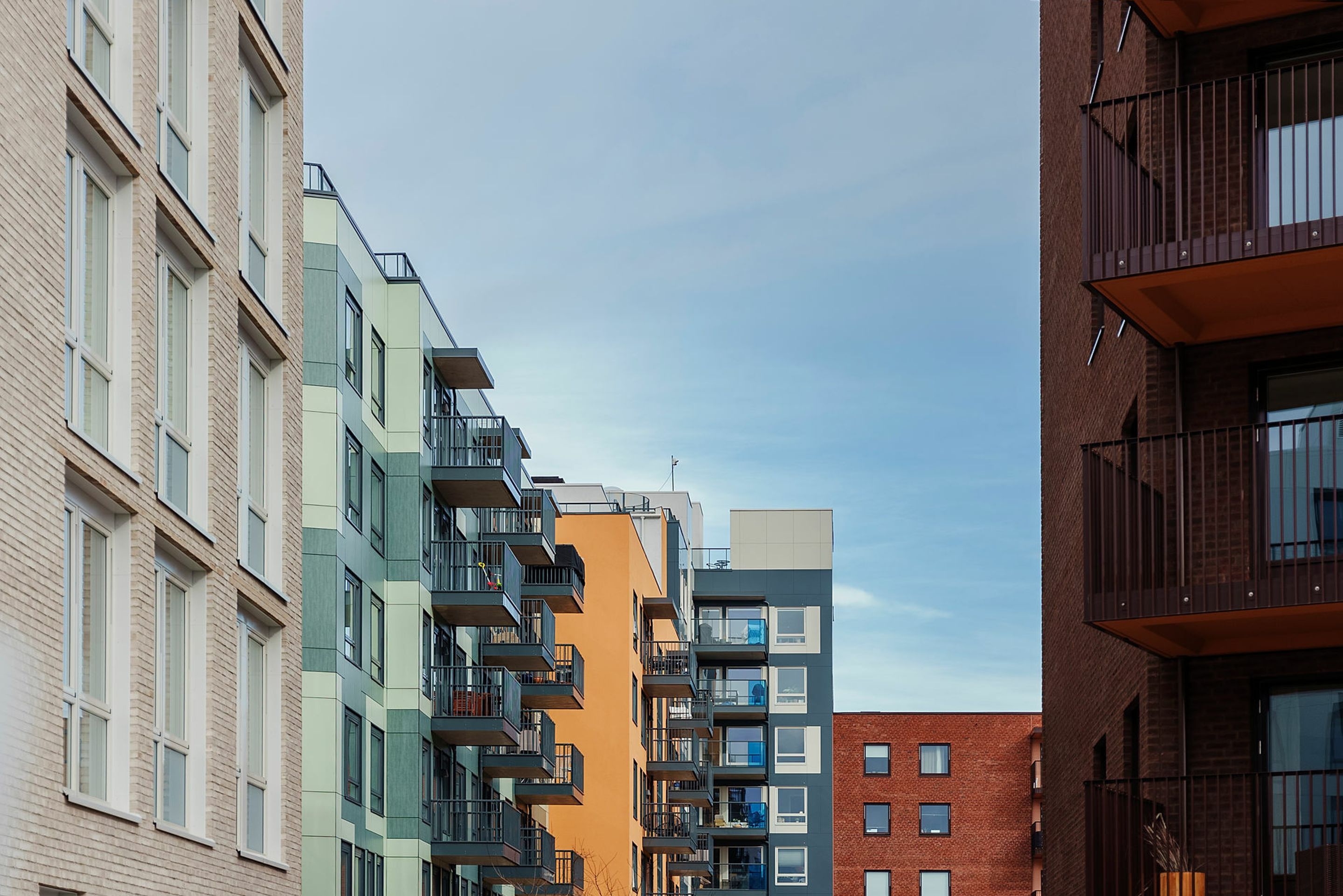 Fasadebilde av boligblokker i ulike farger på Vollebekk
