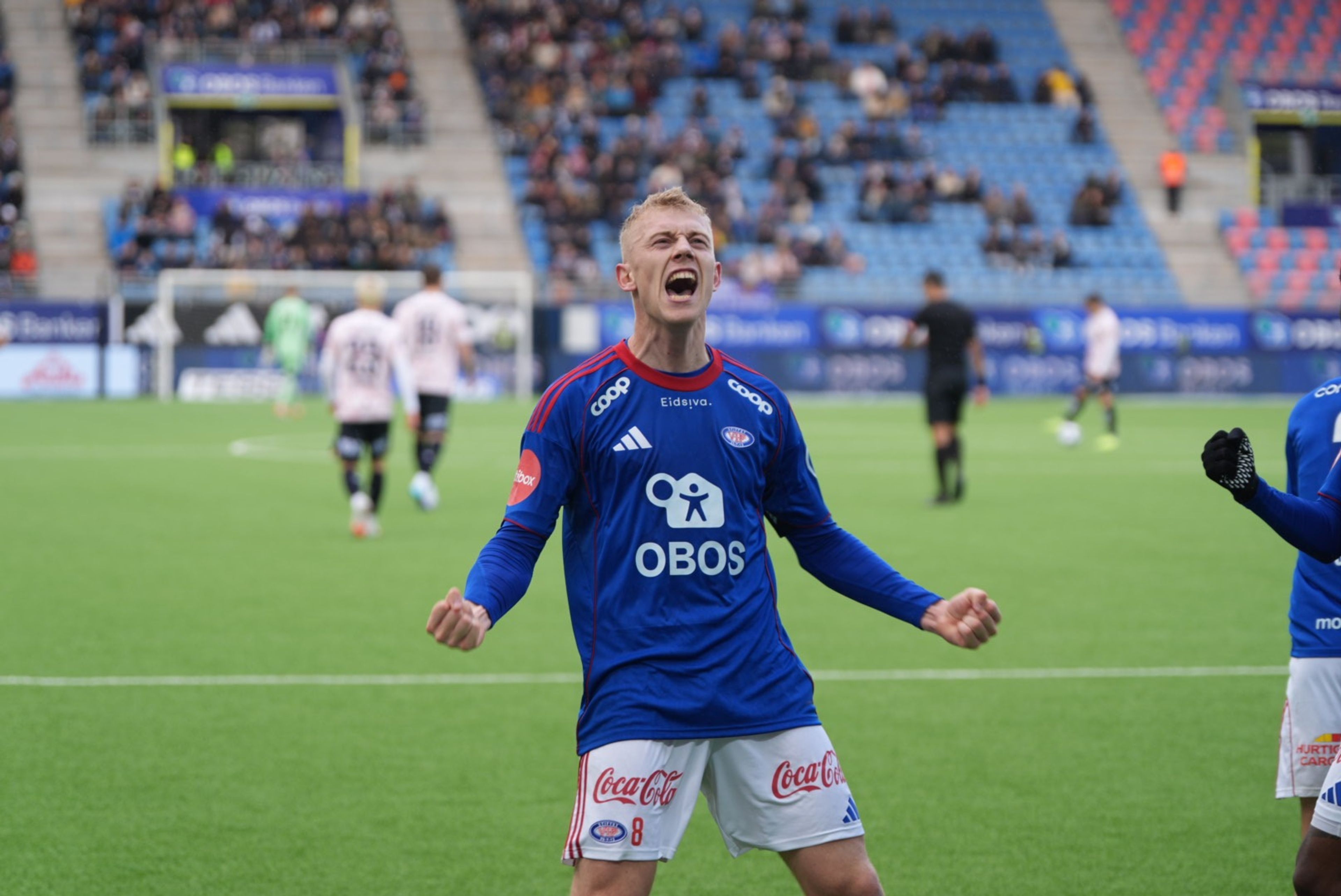 Henrik Bjørdal, fotballspiller på Vålerenga Fotball Elite, jubler mot publikum på stadion.