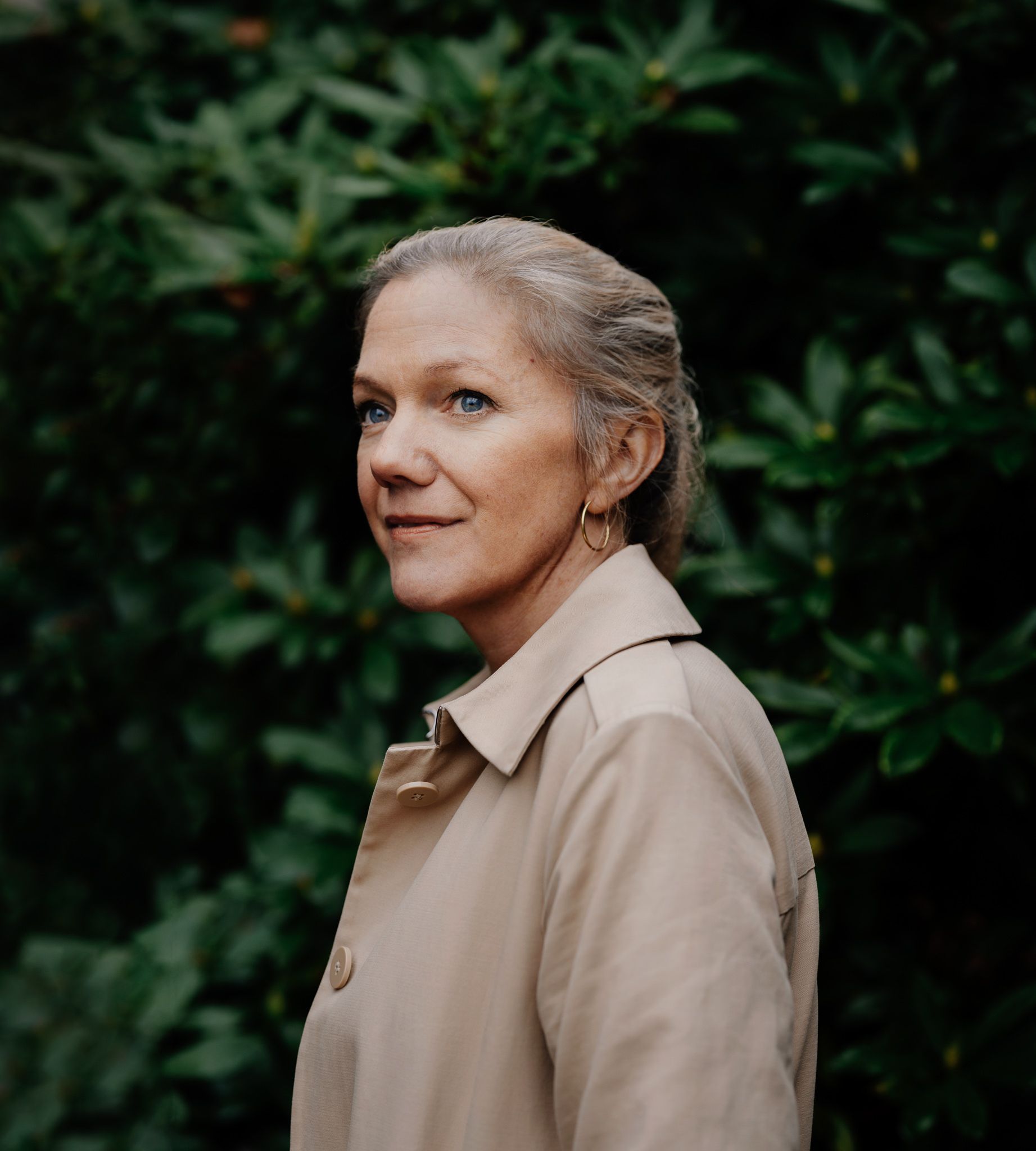 Portrett av Maja Lunde foran en hekk.