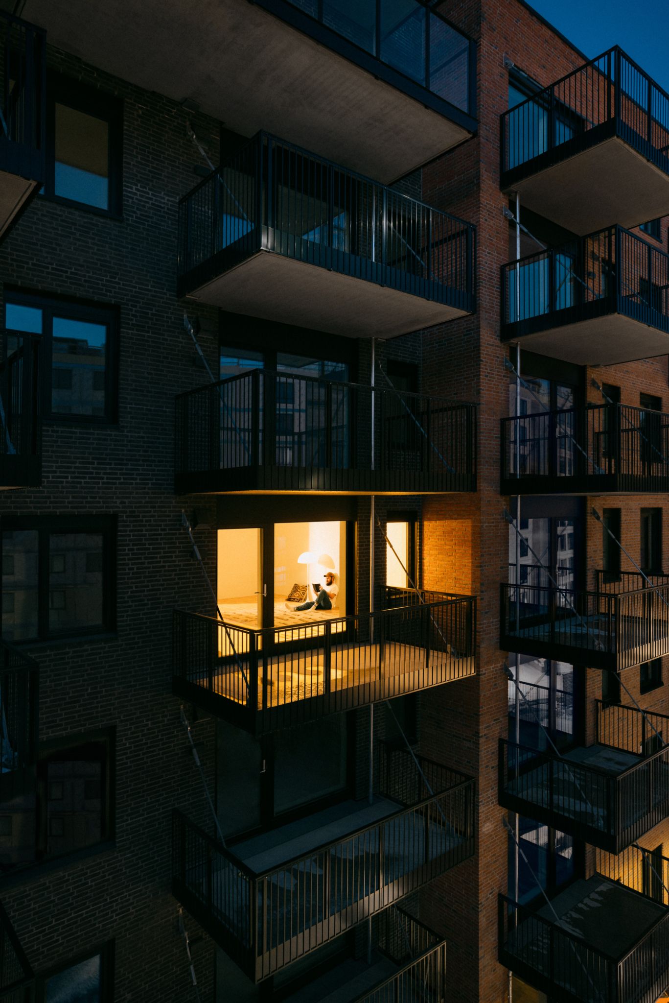 Bildet viser en fasade på Ulven, hvor en leilighet er opplyst.