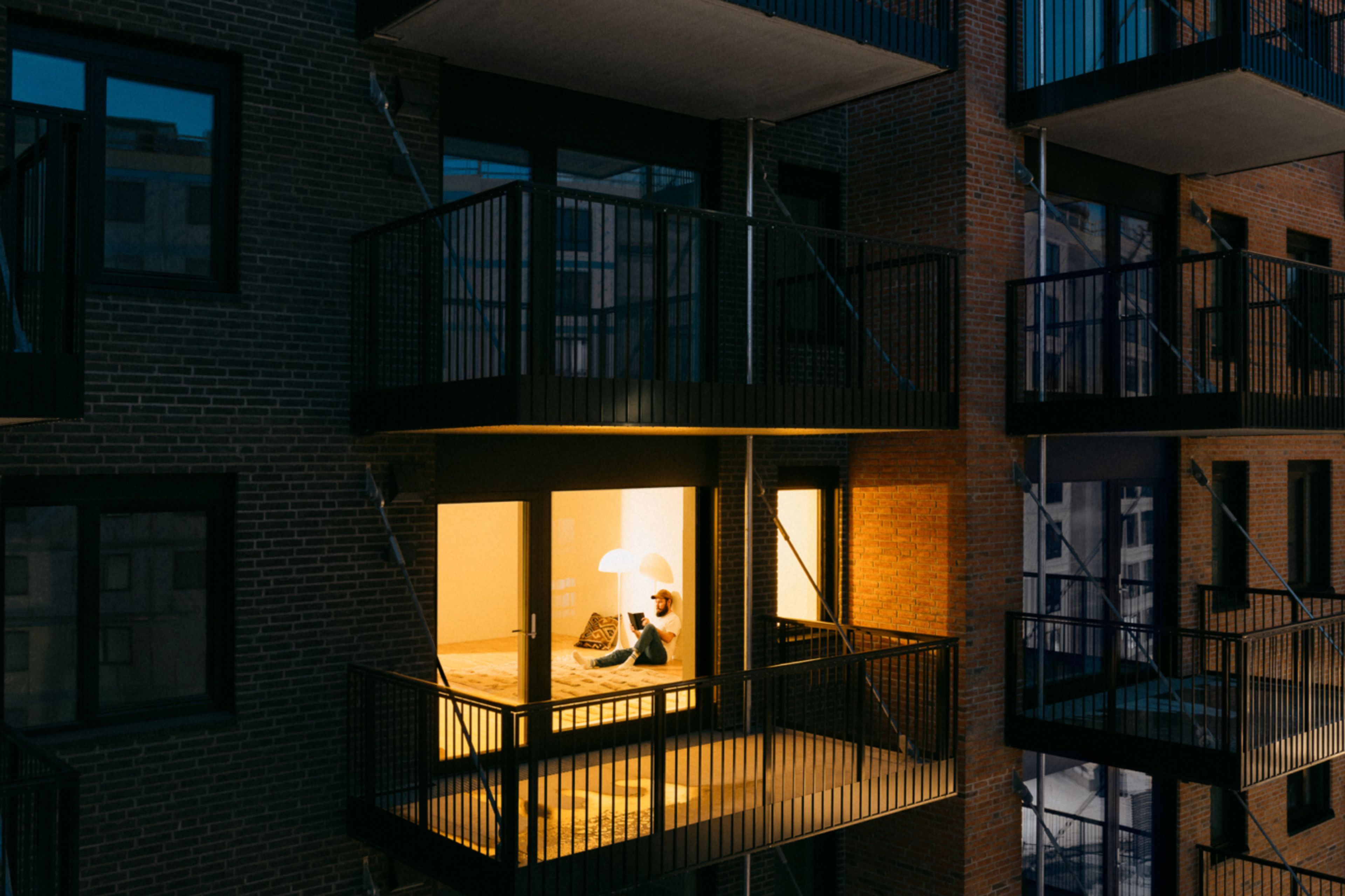 Bildet viser en fasade på Ulven, hvor en leilighet er opplyst.