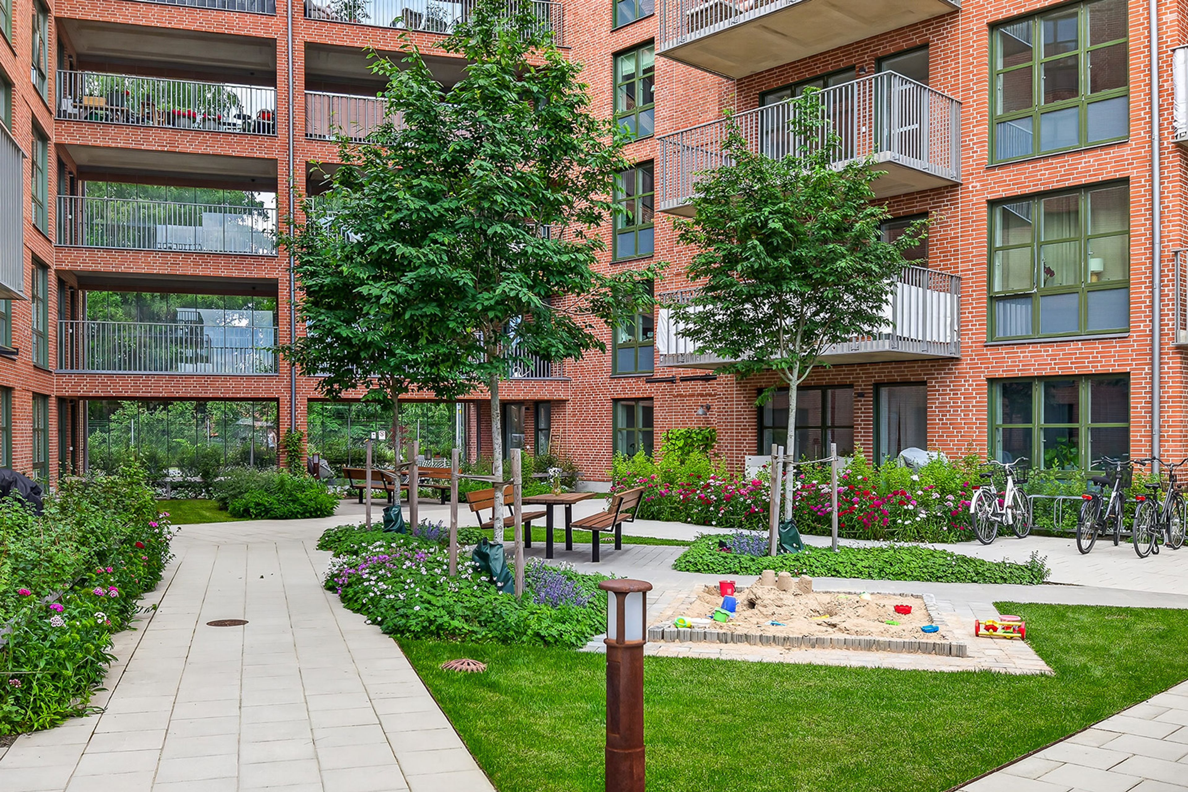 Foto på innergård med sandlåda och sittplatser