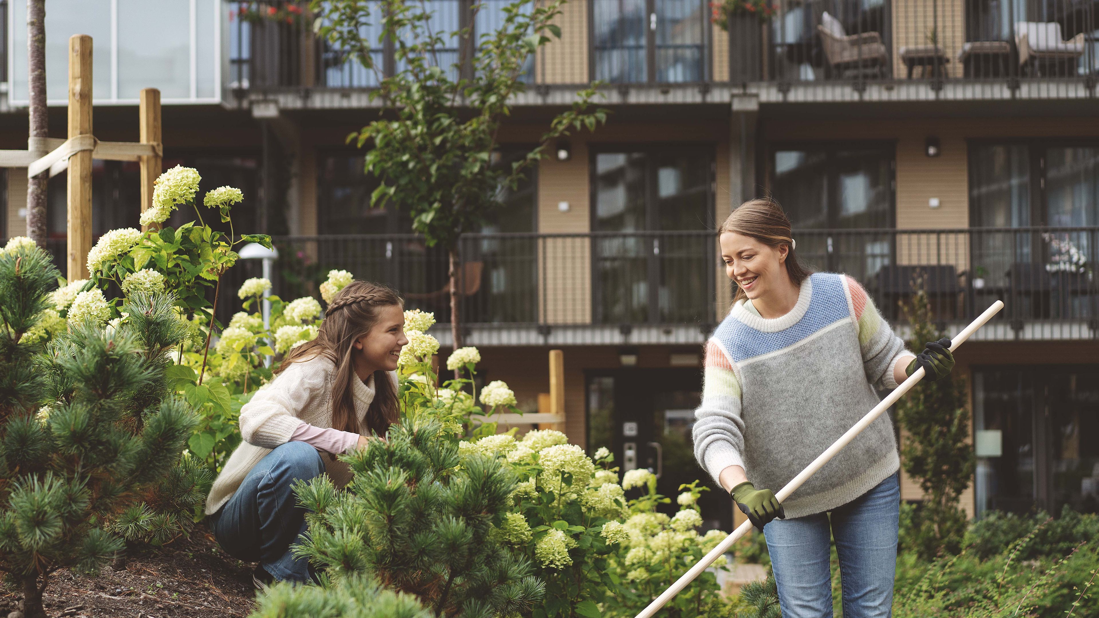 Mamma och dotter i trädgården