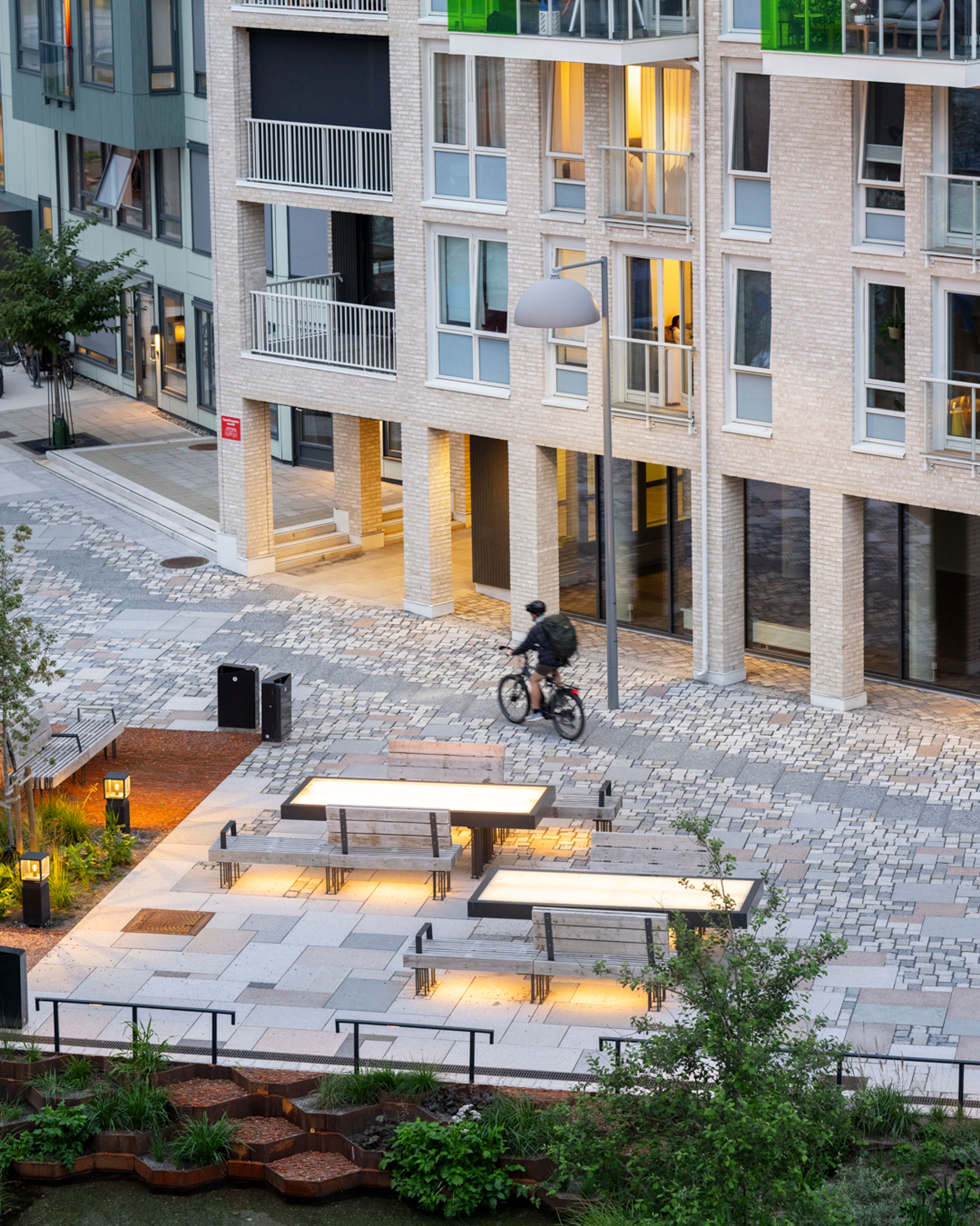 Foto av en mann som sykler gjennom Vollebekk Torgkvartal.