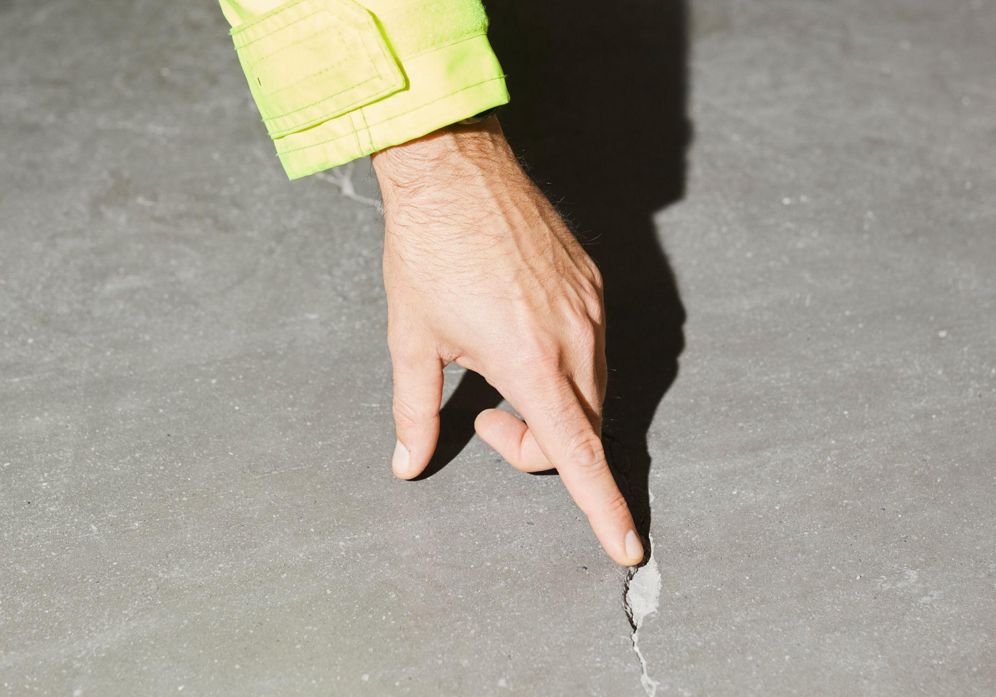 Espen Nygård i Radonmannen AS peker mot en sprekk i et betonggulv.