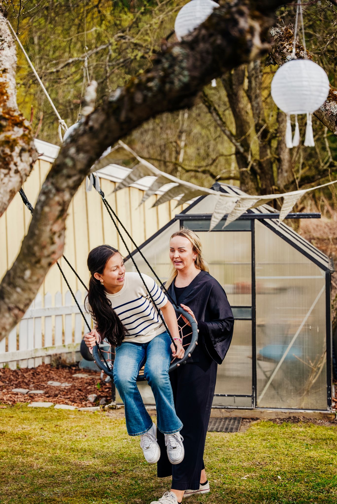 Mamma Camilla gir datteren Melissa fart i husken i hagen.