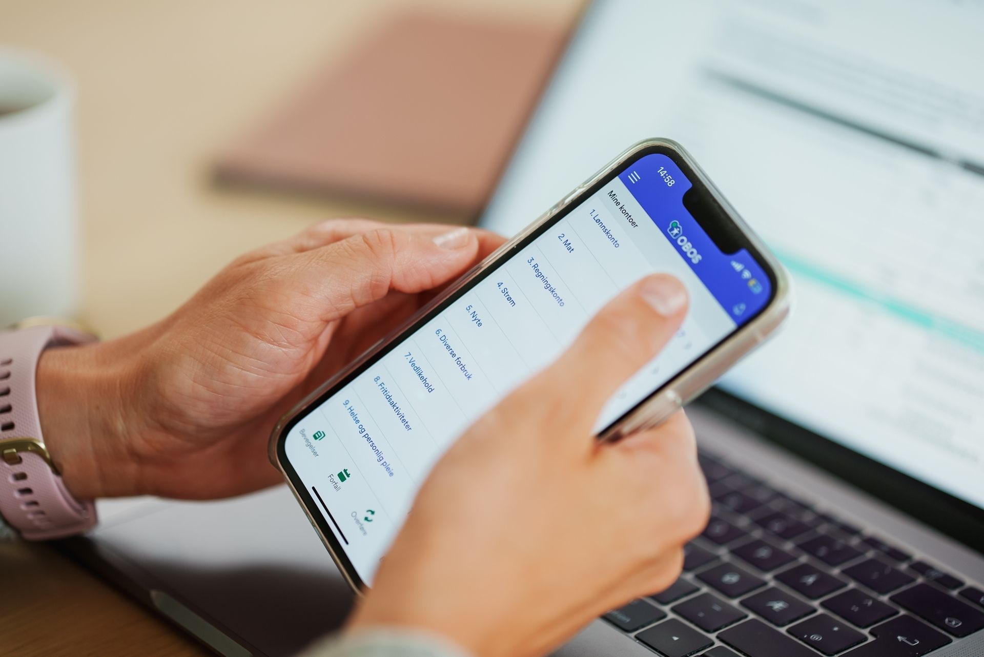 Kvinne holder i telefonen sin med nettbanken åpen
