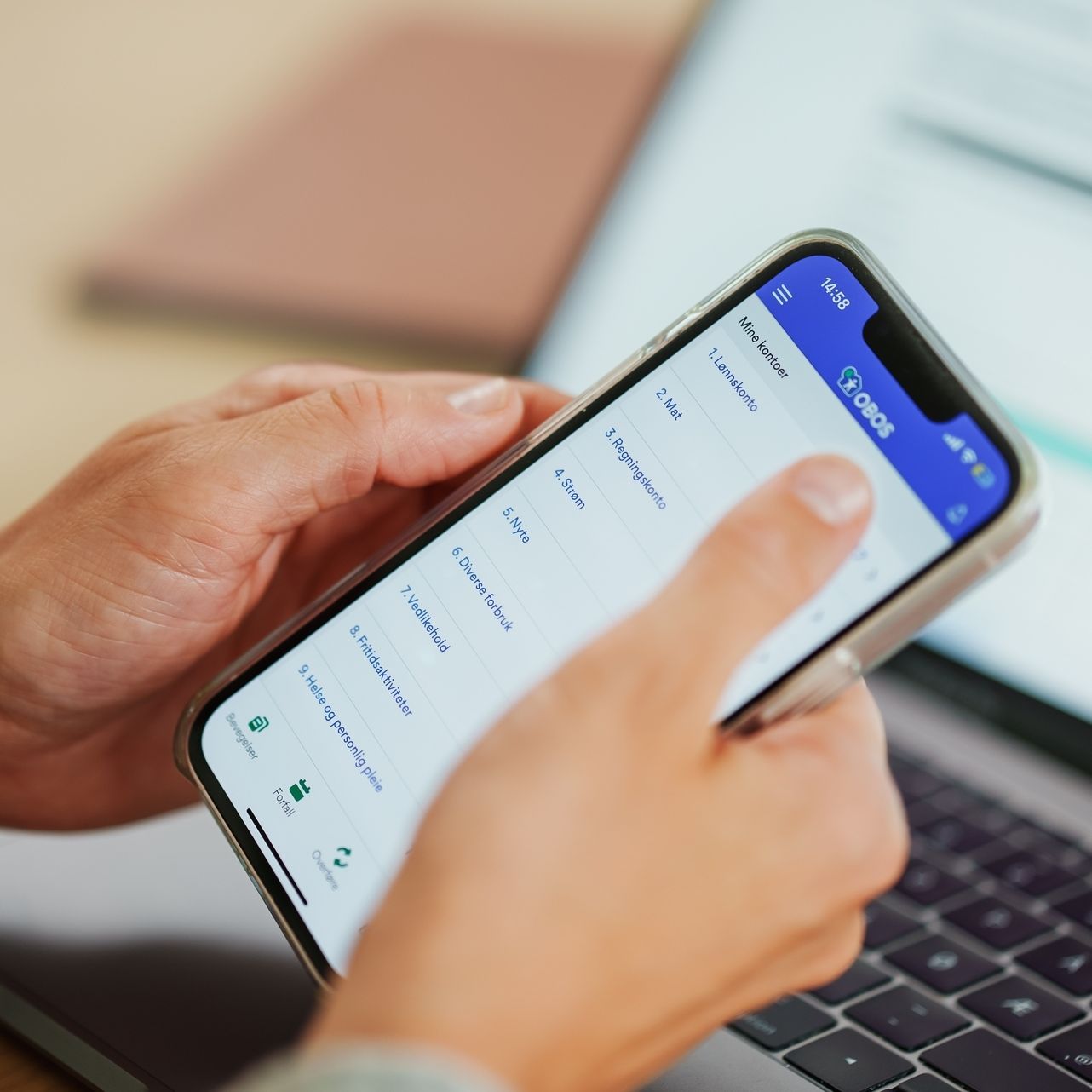 Kvinne holder i telefonen sin med nettbanken åpen