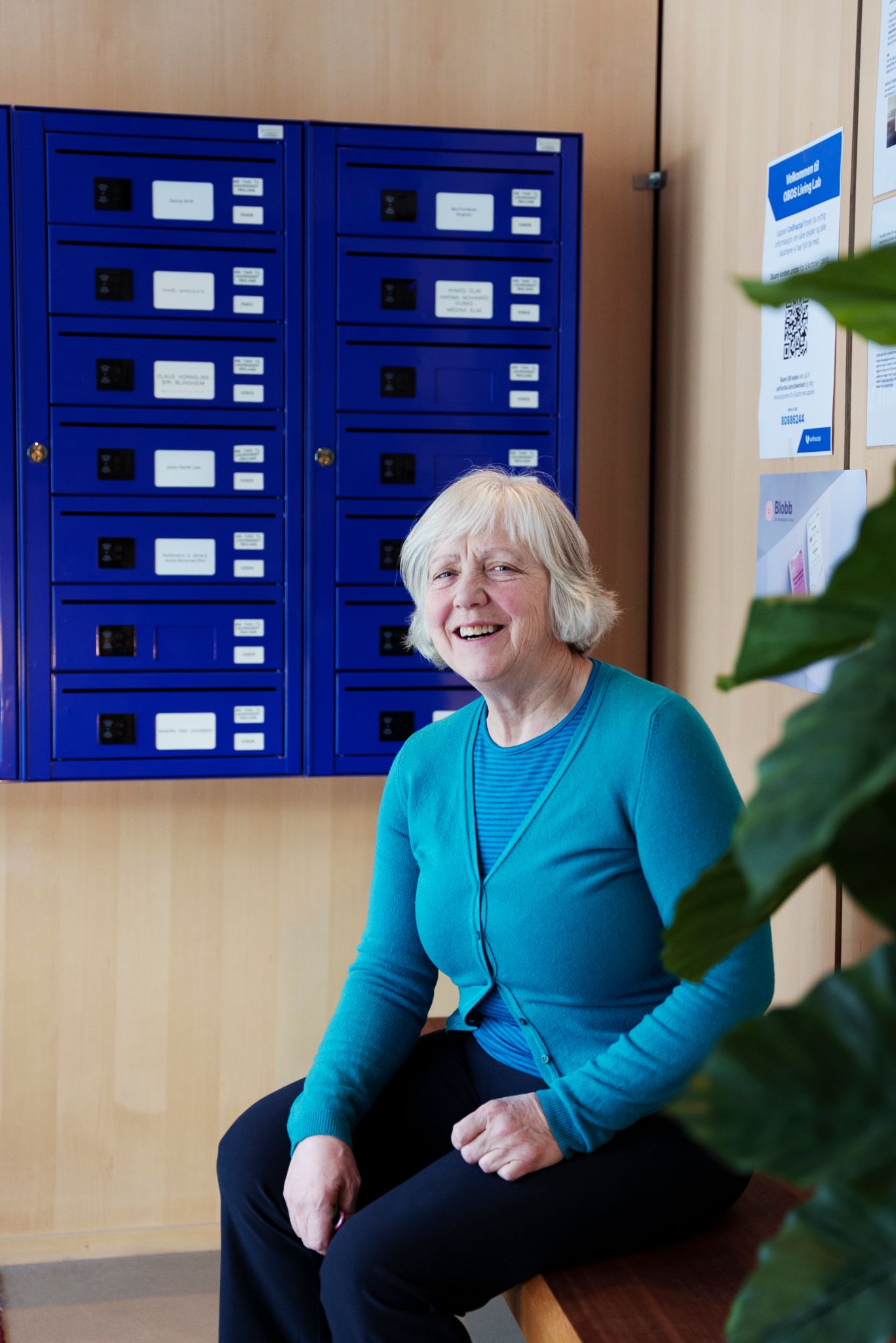 Beboer i OBOS Living Lab, Else Bakkehaug, sitter foran blå postkasser