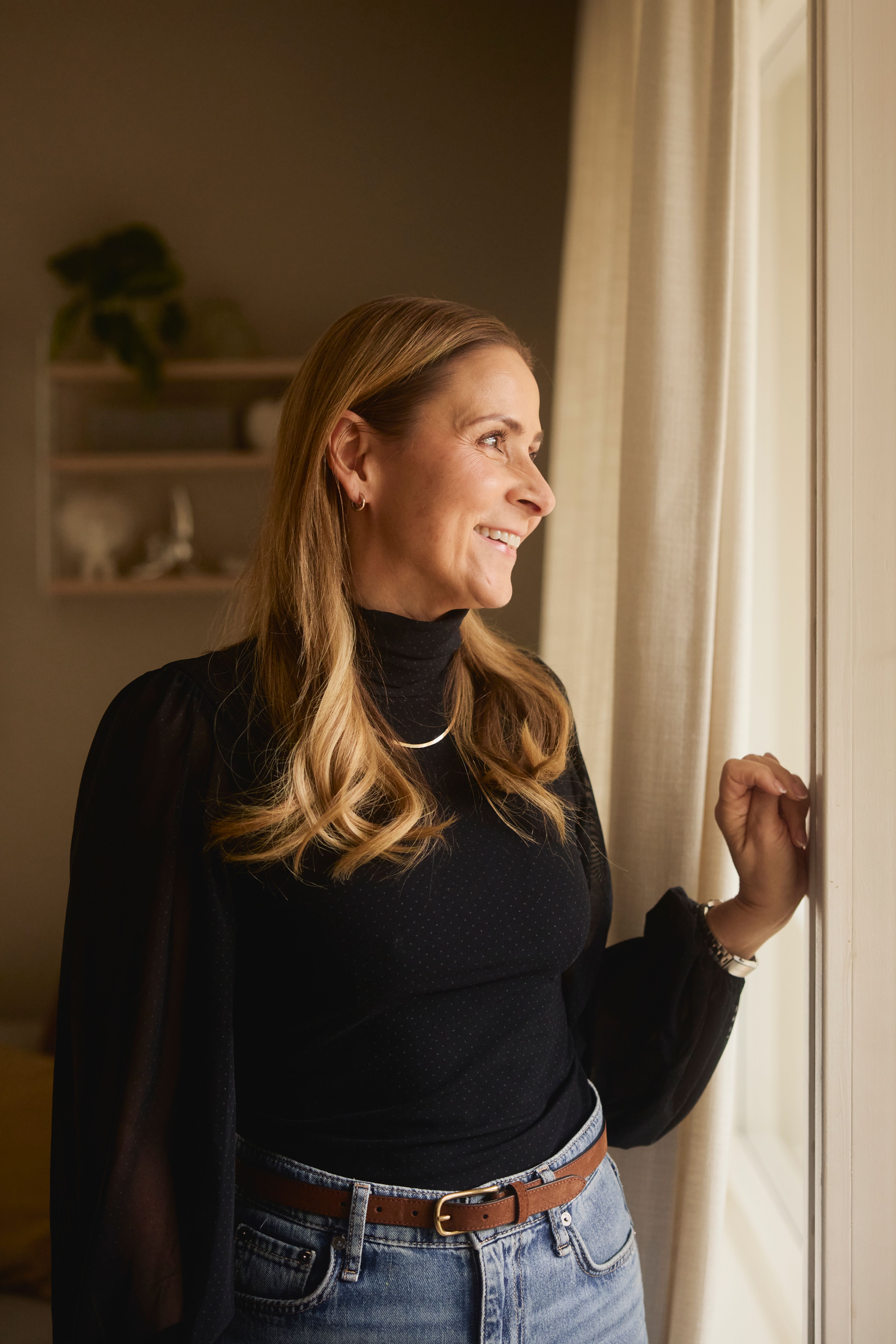 Bilde av Tanya som ser ut av vinduet i leiligheten sin.