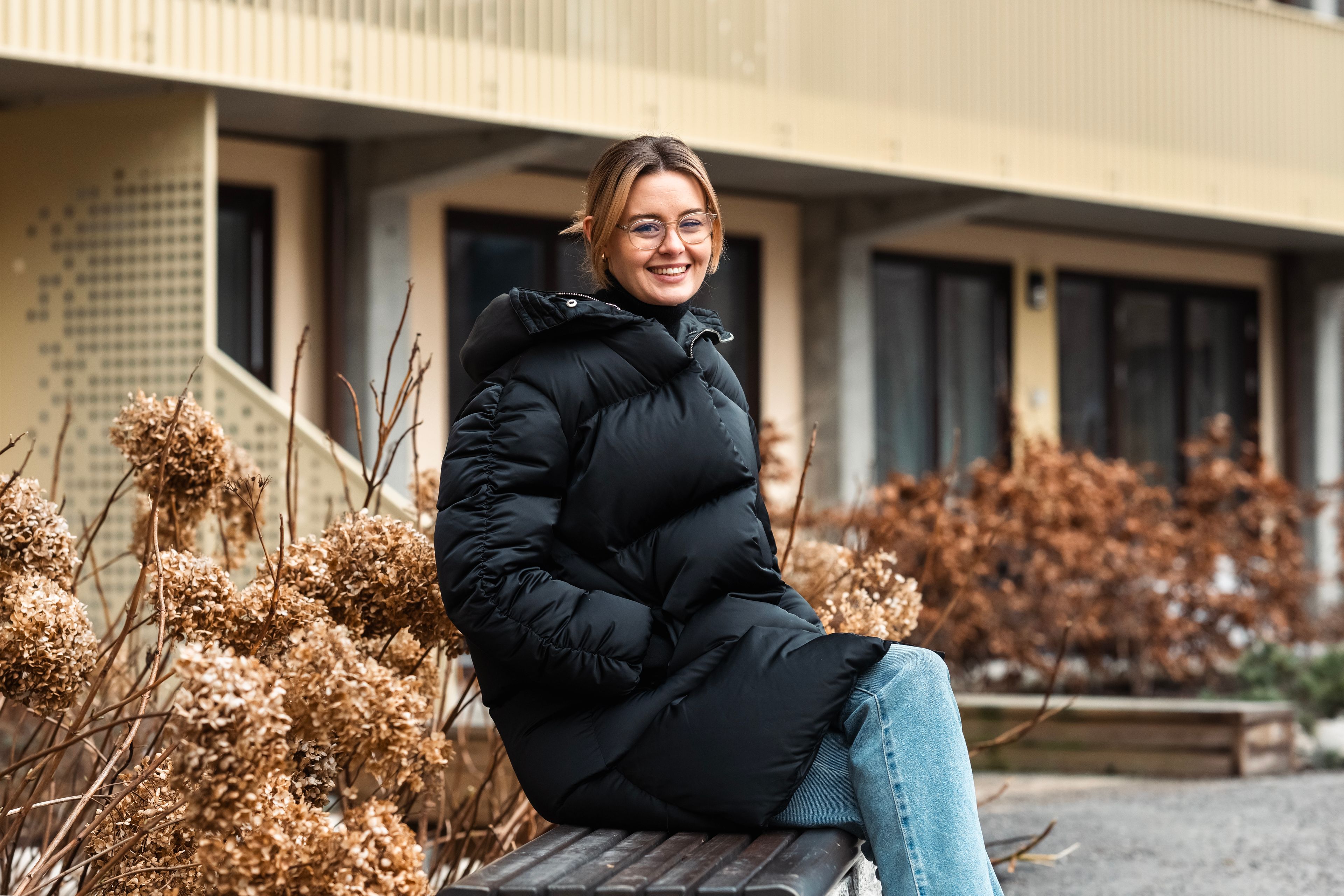 Ragnhild Helene Løvli sitter på en benk i et borettslag som har tilrettelagt eldre.