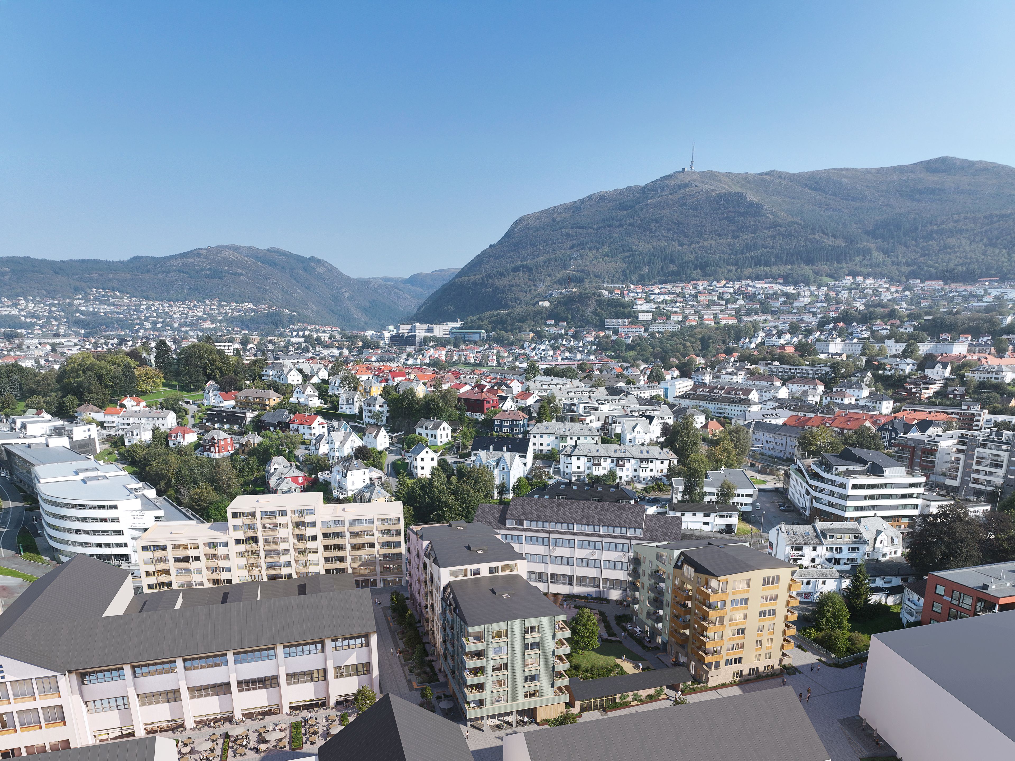 Oversikt over nærområde med allmenning og prosjektet i forgrunnen.