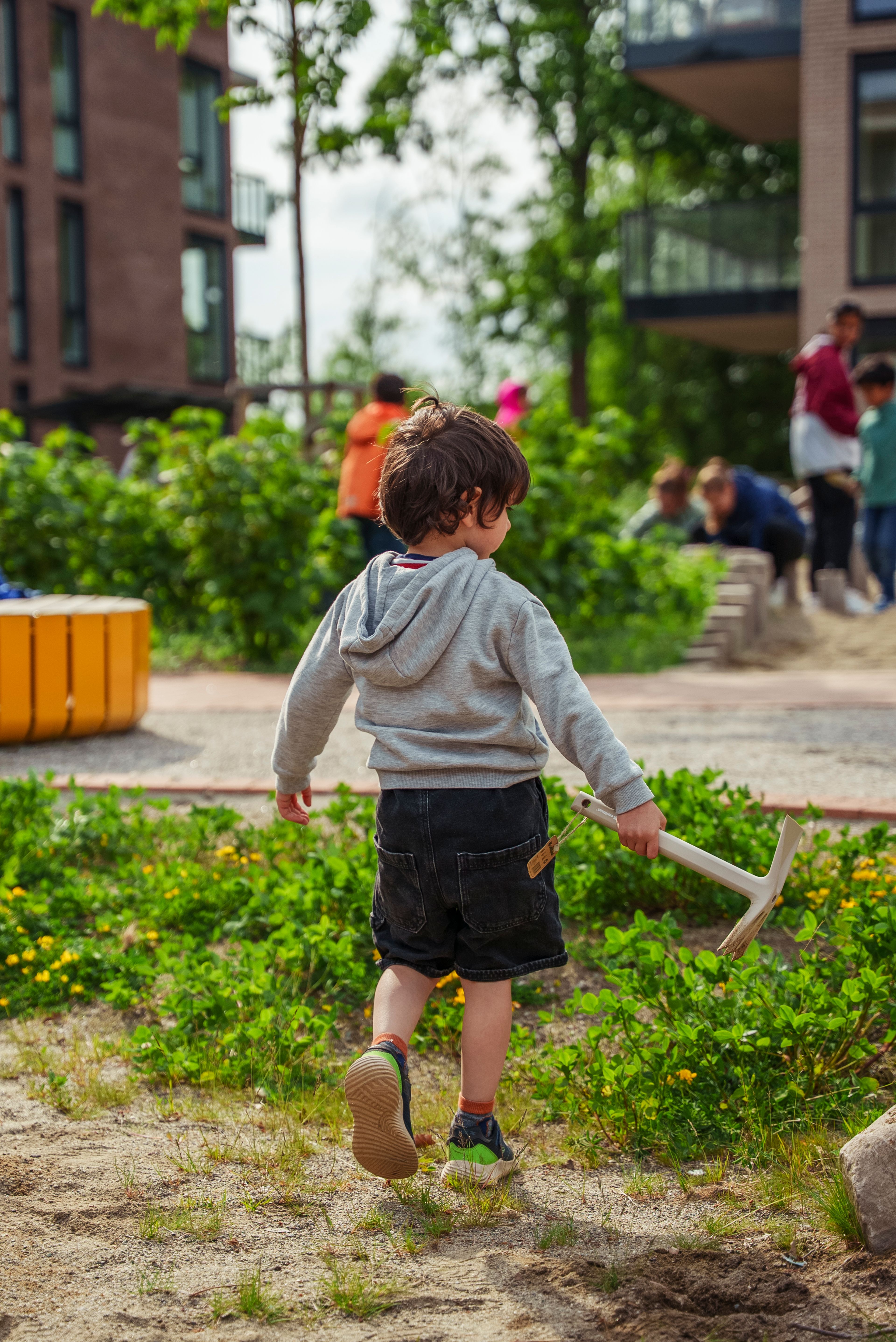 En gutt jobber på dugnad med en hakke
