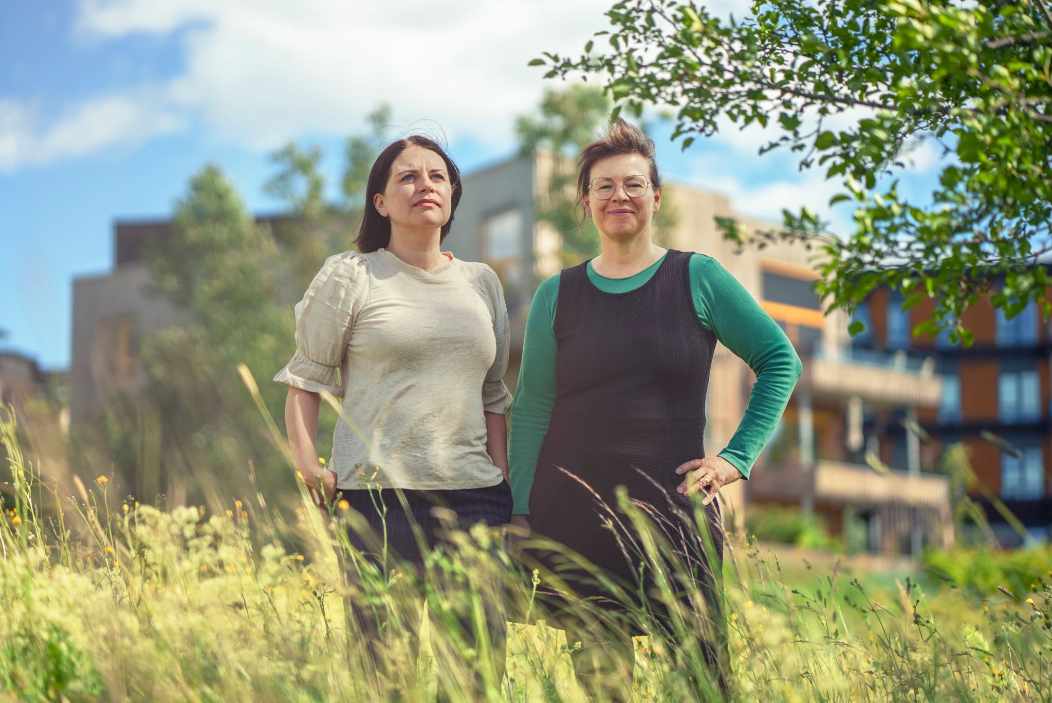 Bilde av Ingunn Randa og Hanne Løvbrøtte ute på en eng foran et leilighetsbygg