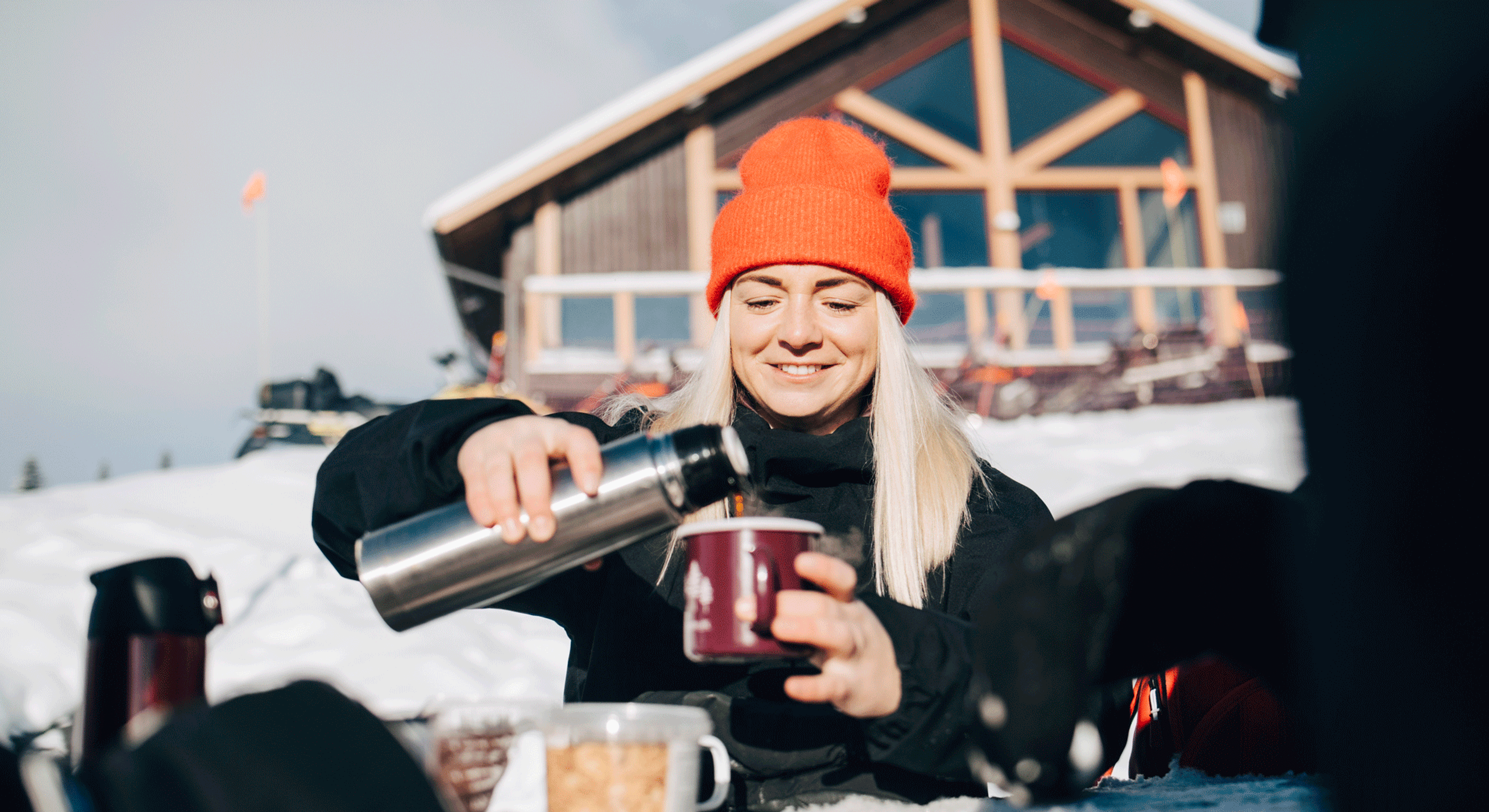 tjej som häller upp kaffe ur termos utomhus