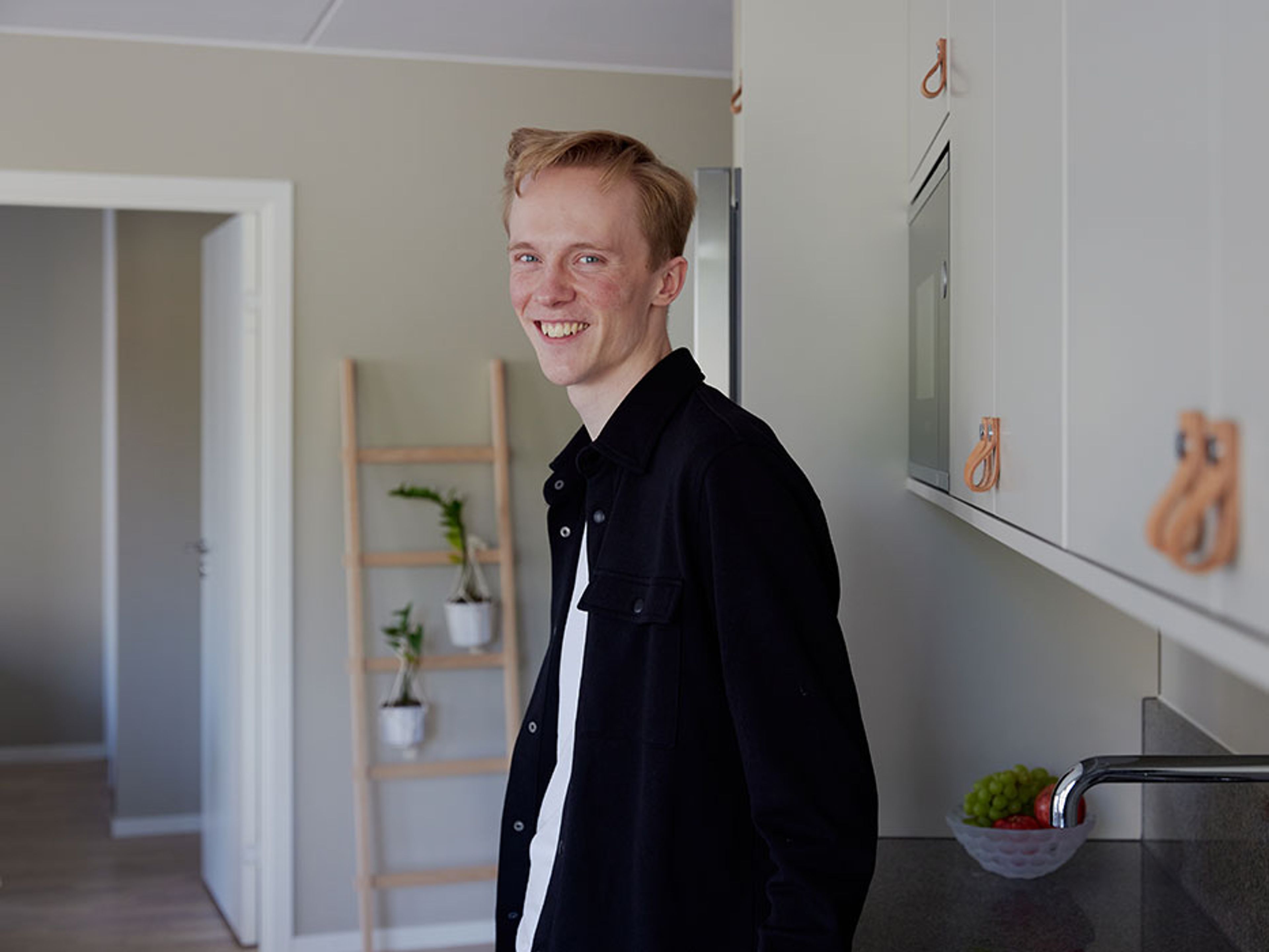 Axel lutar sig mot diskbänken i köket