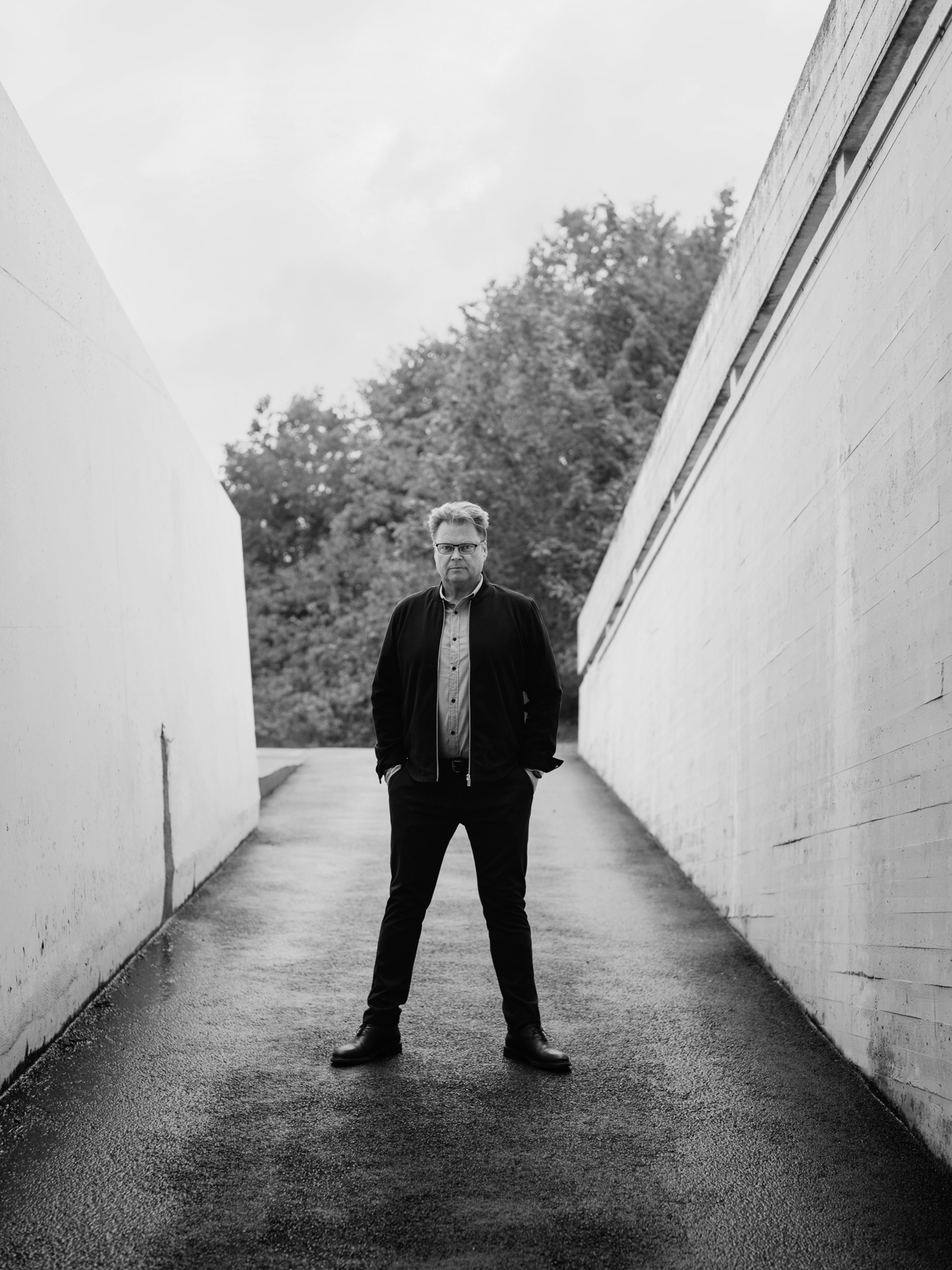 Svart/hvitt foto av Jørn Lier Horst. Han står bredbent og ser rett i kameraet.