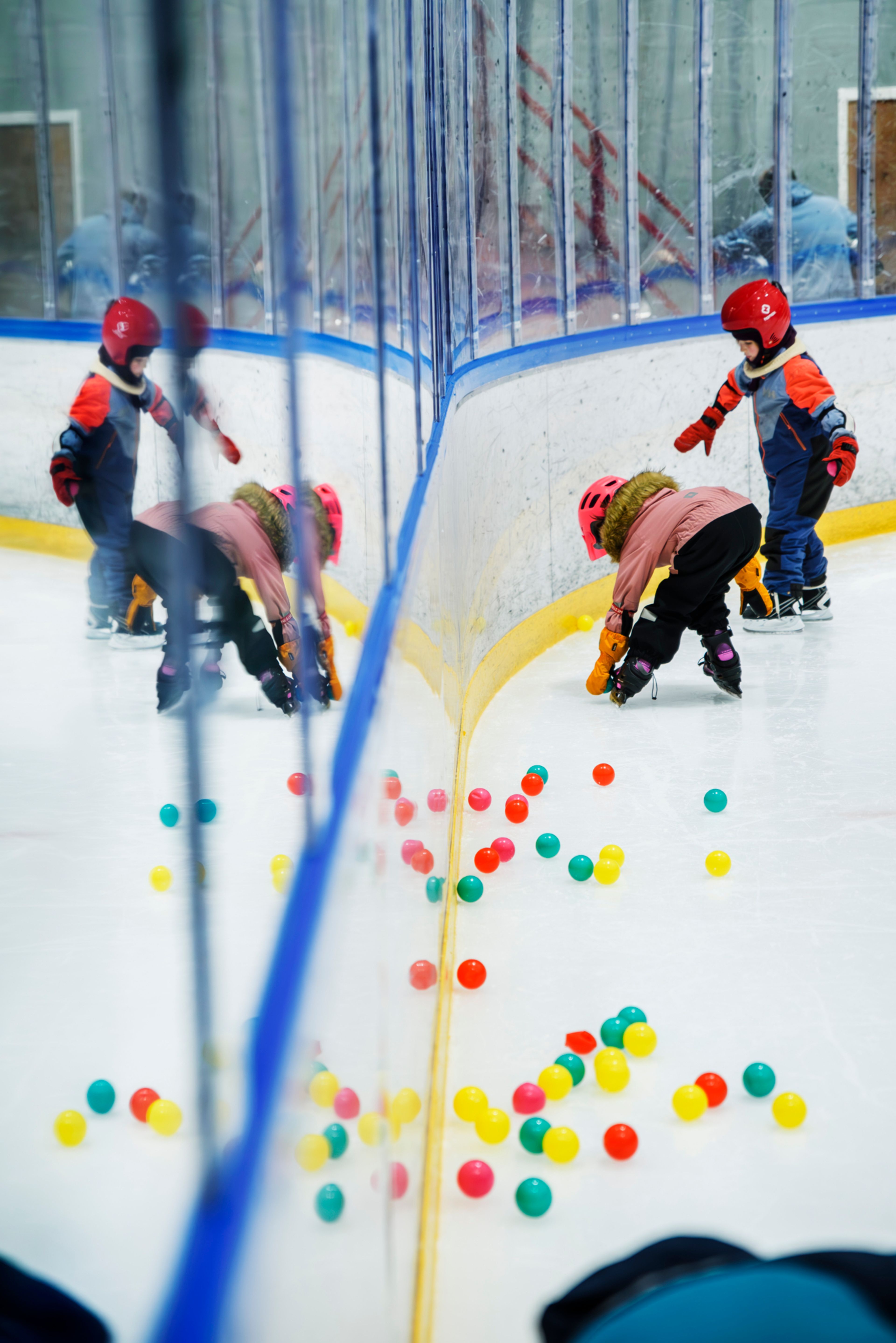 Foto av barn som plukker ballen fra skøyteisen.