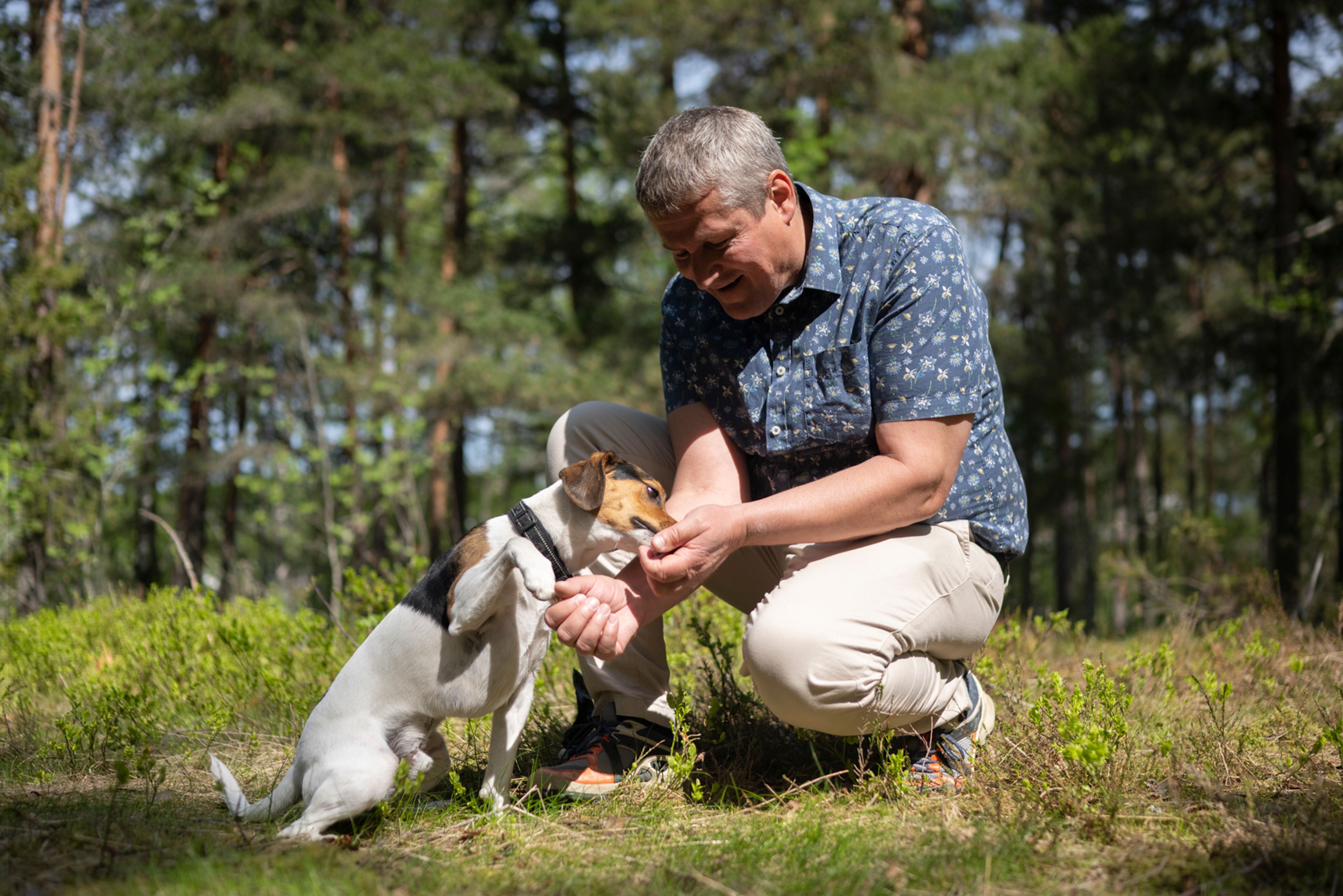 Foto av kjøperen Tor Helge med hunden sin i skogen.