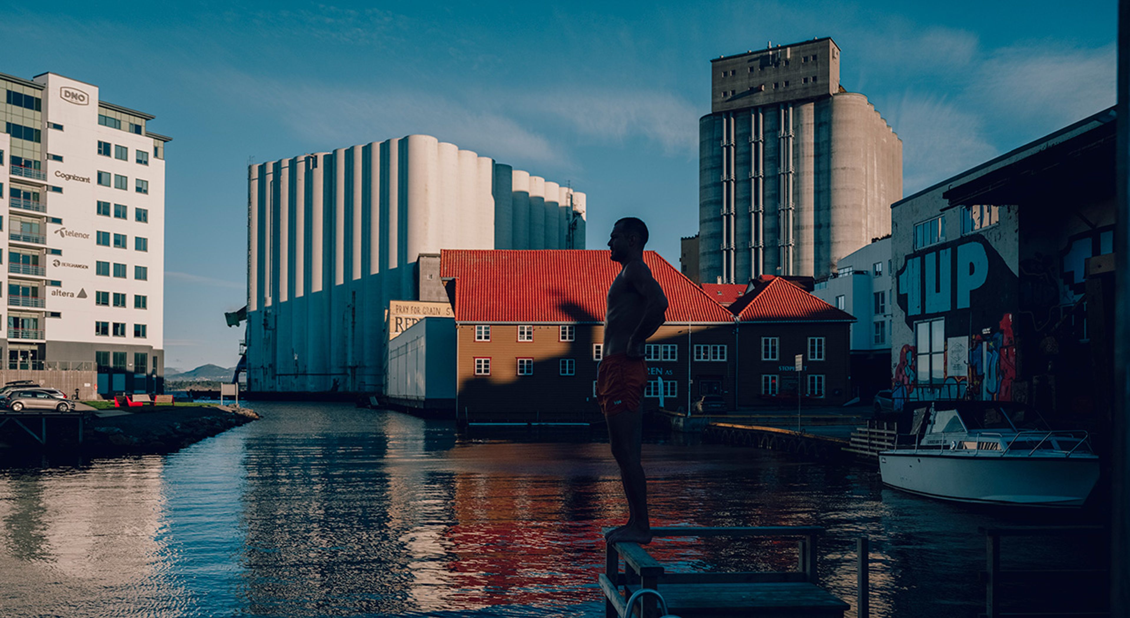 Foto av en mann som skal stupe i vannet i Badedammen Brygge.