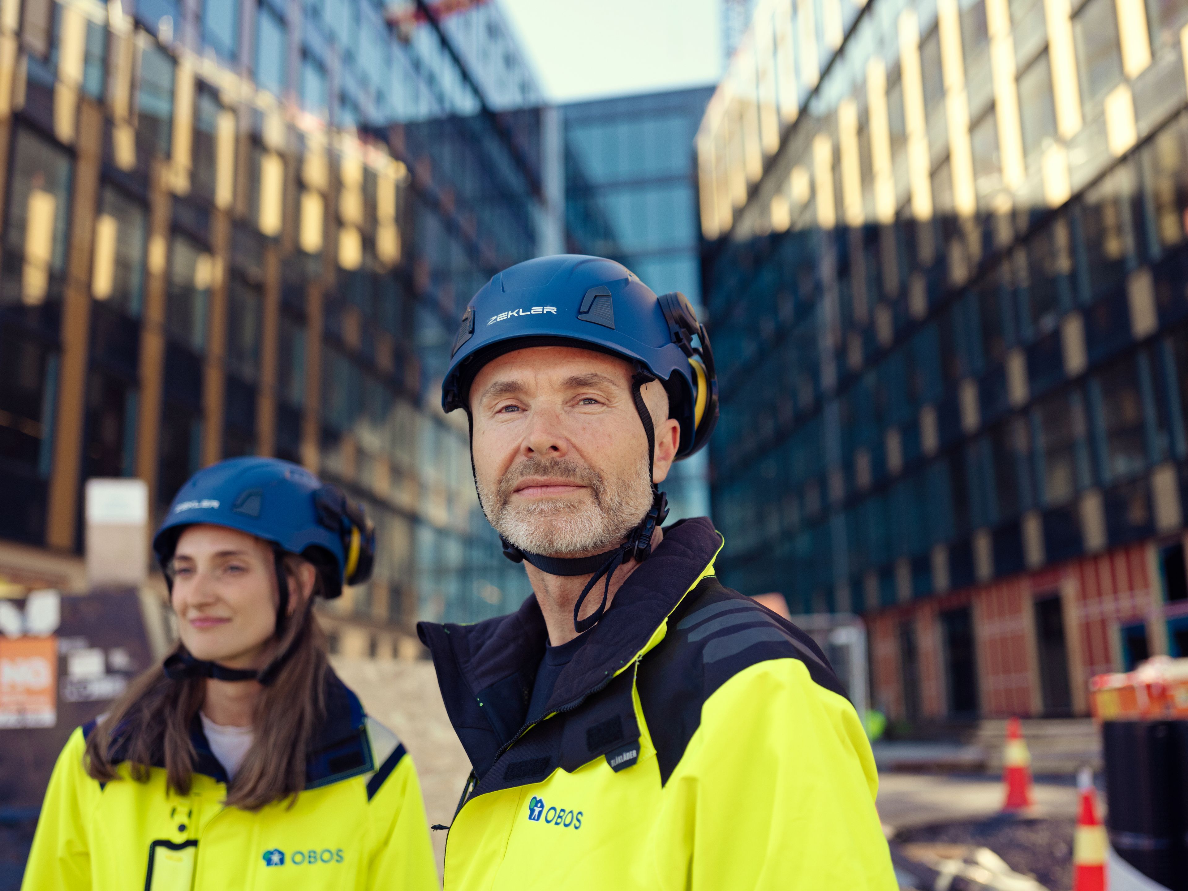 Mann og kvinne i arbeidsklær på en byggeplass