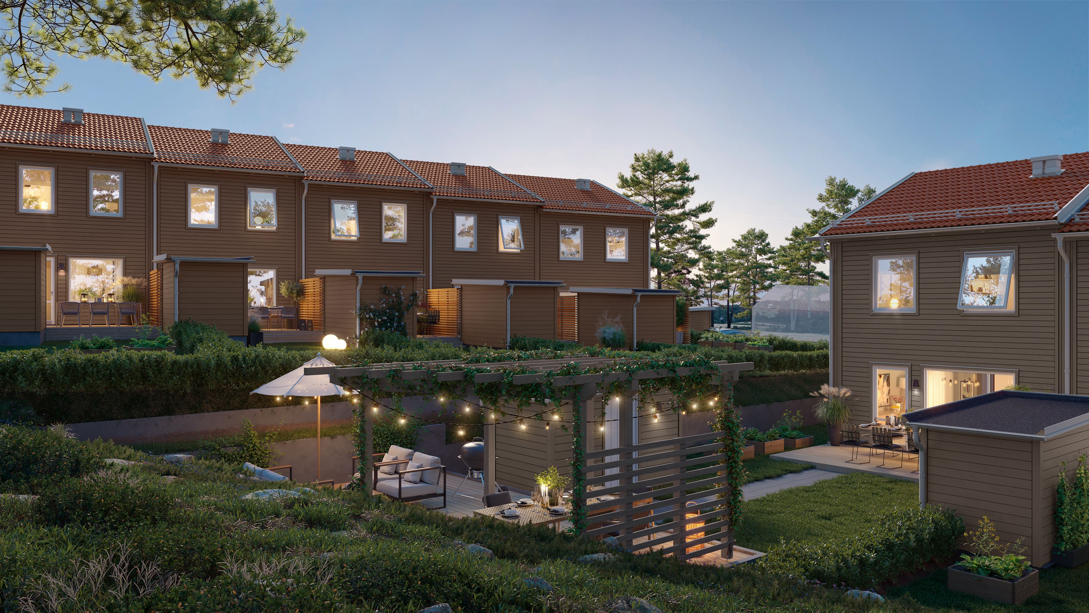 Skymningsbild med mysbelysning och pergola från baksidan av radhusen i Brf Björnvaktaren i Vallentuna