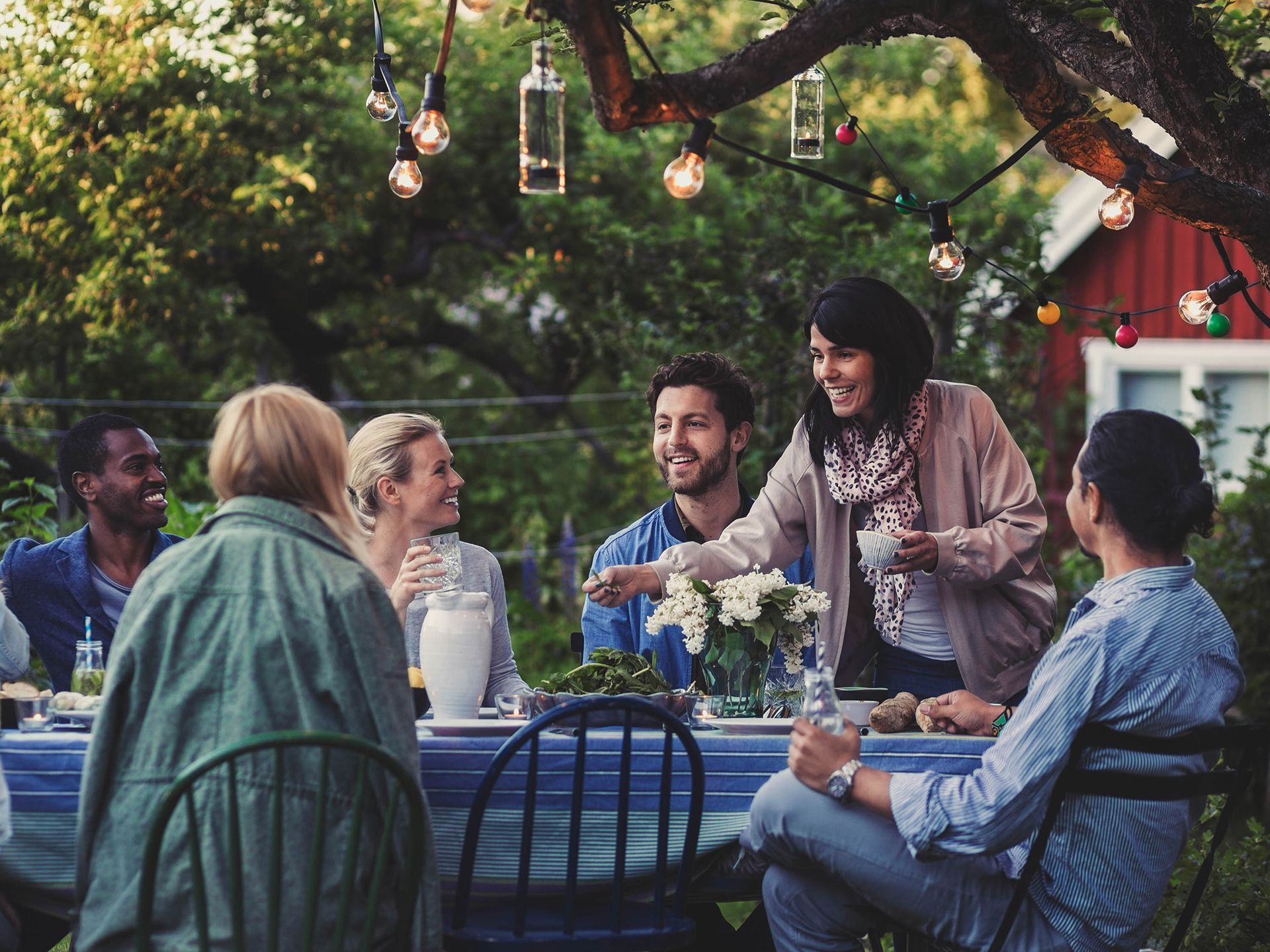 Ett sällskap i alla olika typer av åldrar som har det trevligt runt ett bord