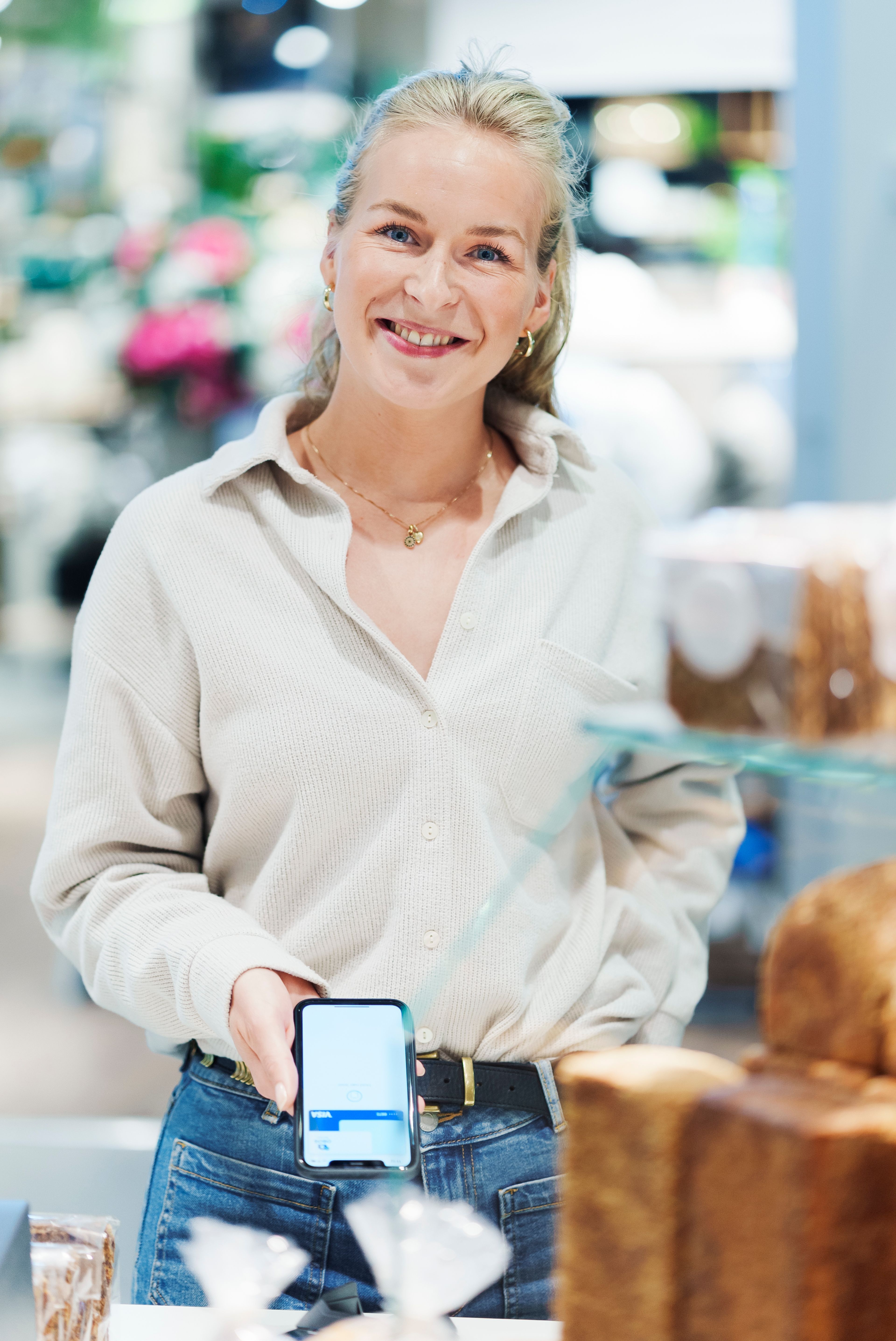 Jente som viser frem Apple Pay på telefonen sin