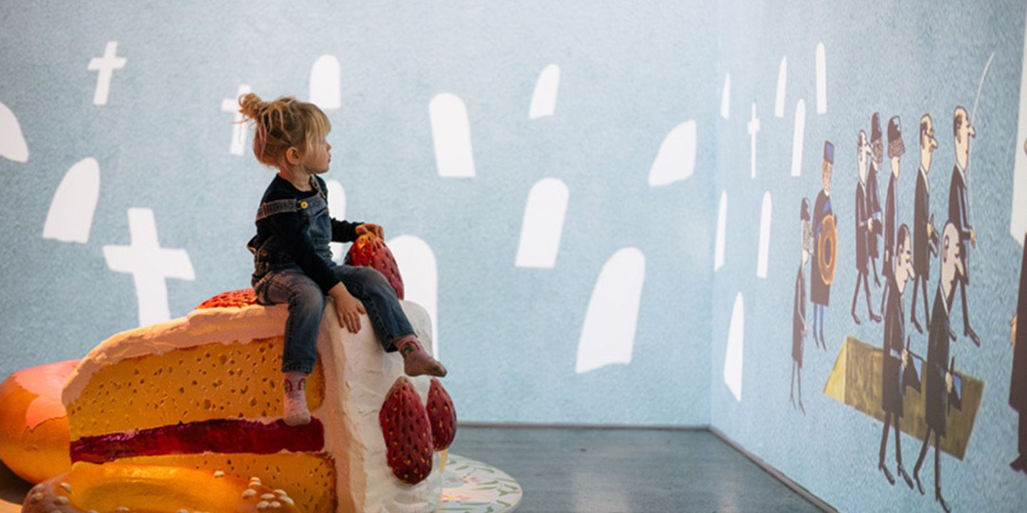 Barn som sitter på en tårta i en utställning på Junibacken
