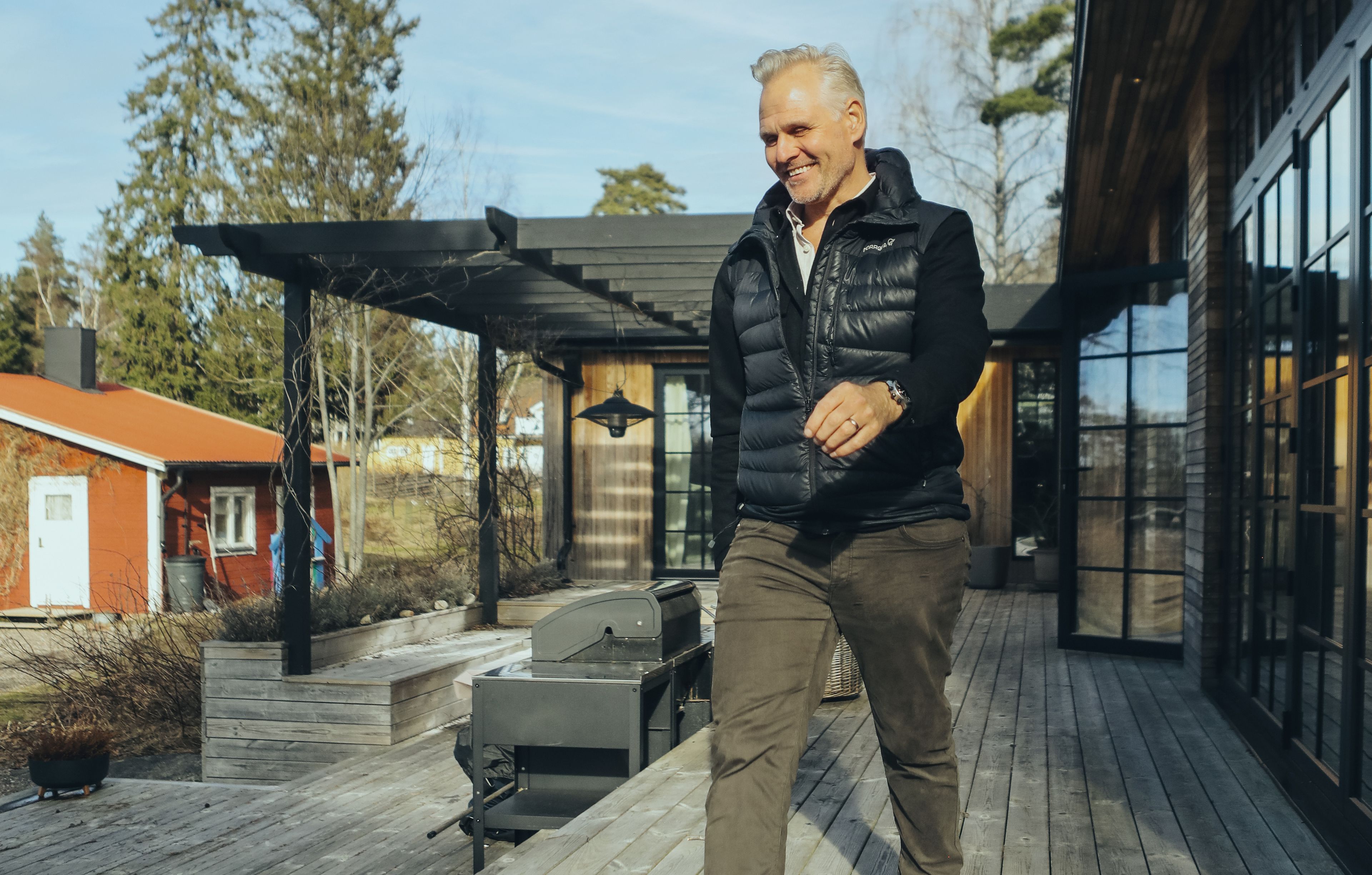 Medlemmen Andreas stående på altanen utanför sitt nybyggda gästhus