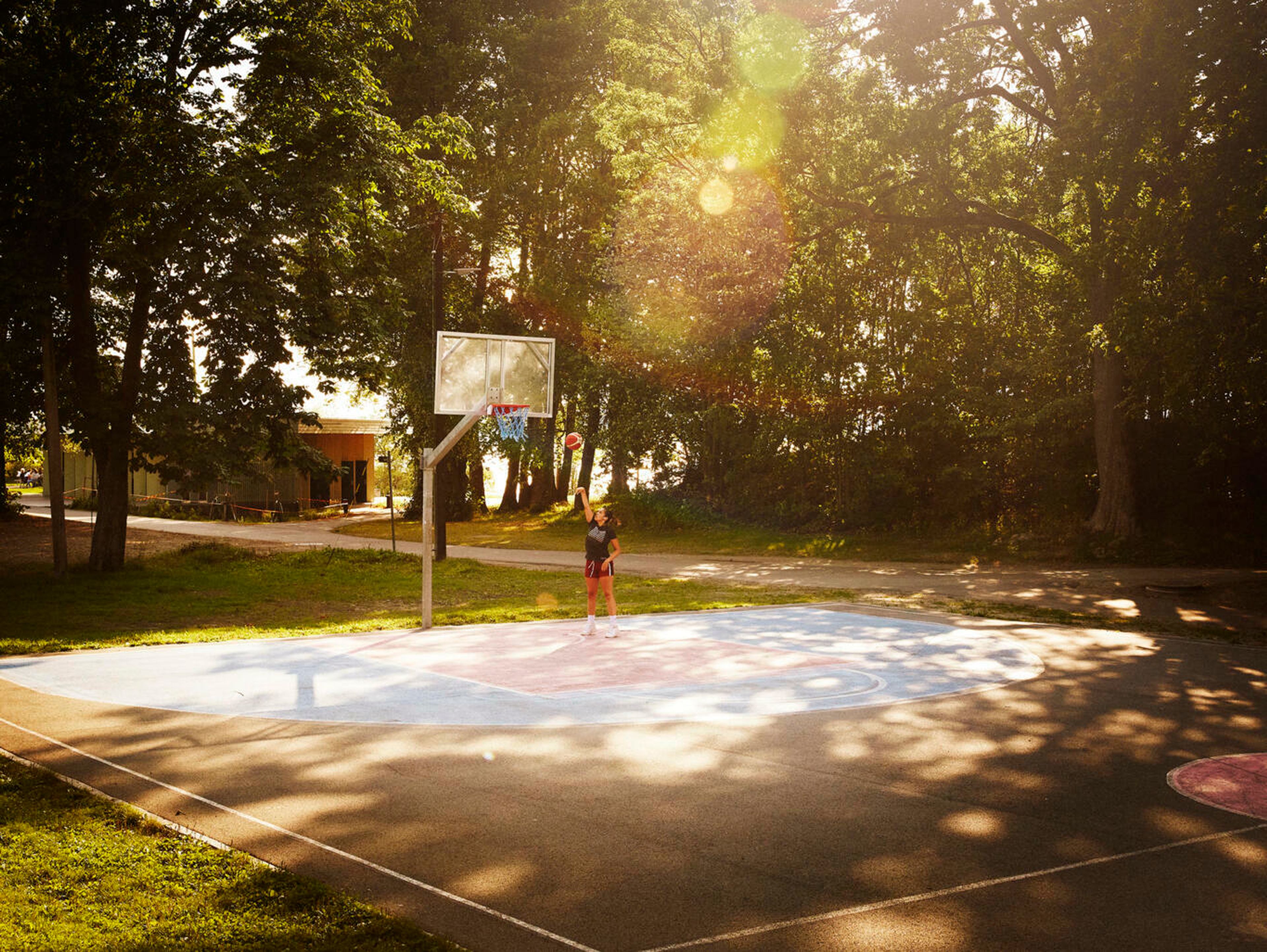 Bildet av en person som spiller basket på en basketbane.