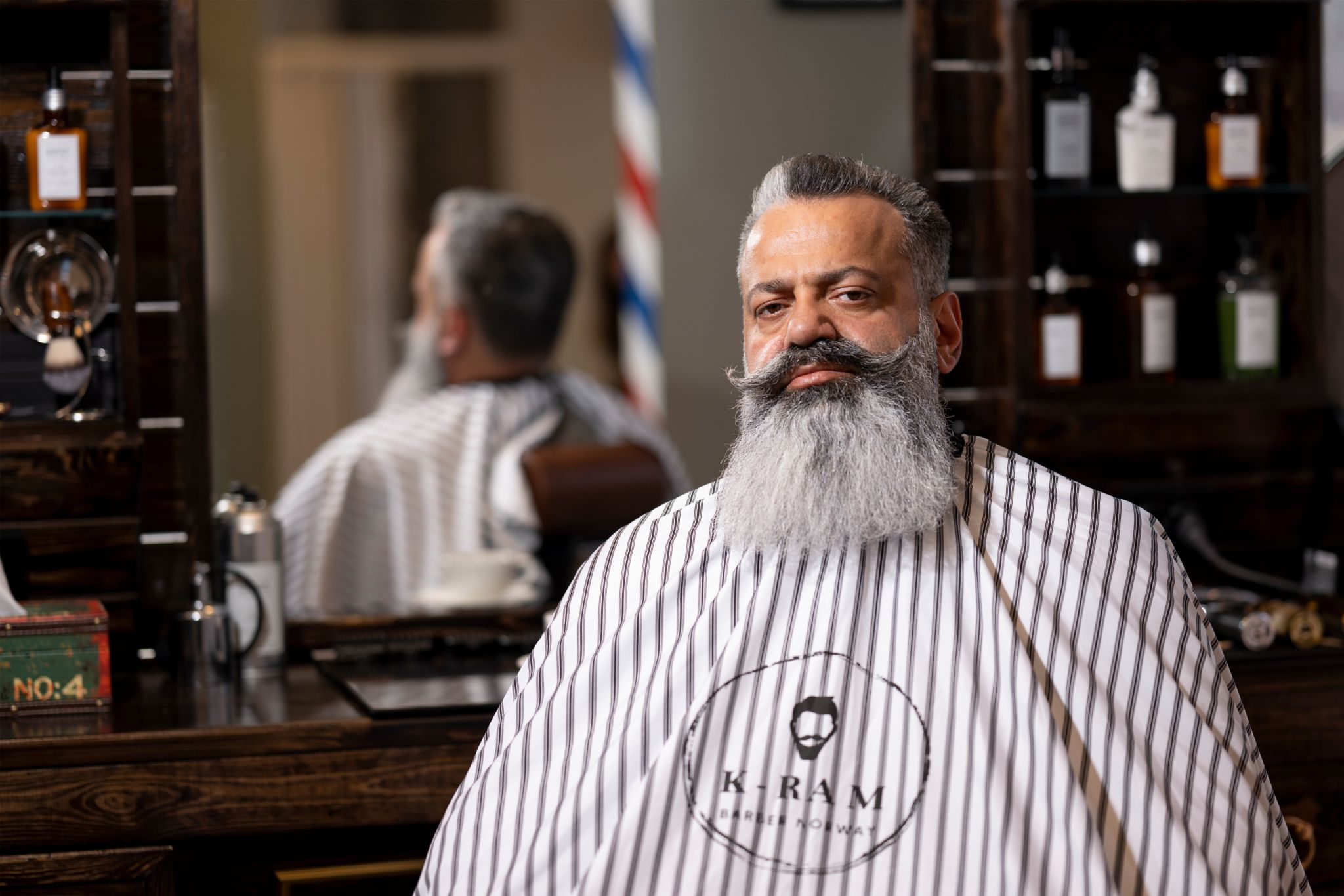 Shahram sitter i stolen i frisørsalongen til Karam.