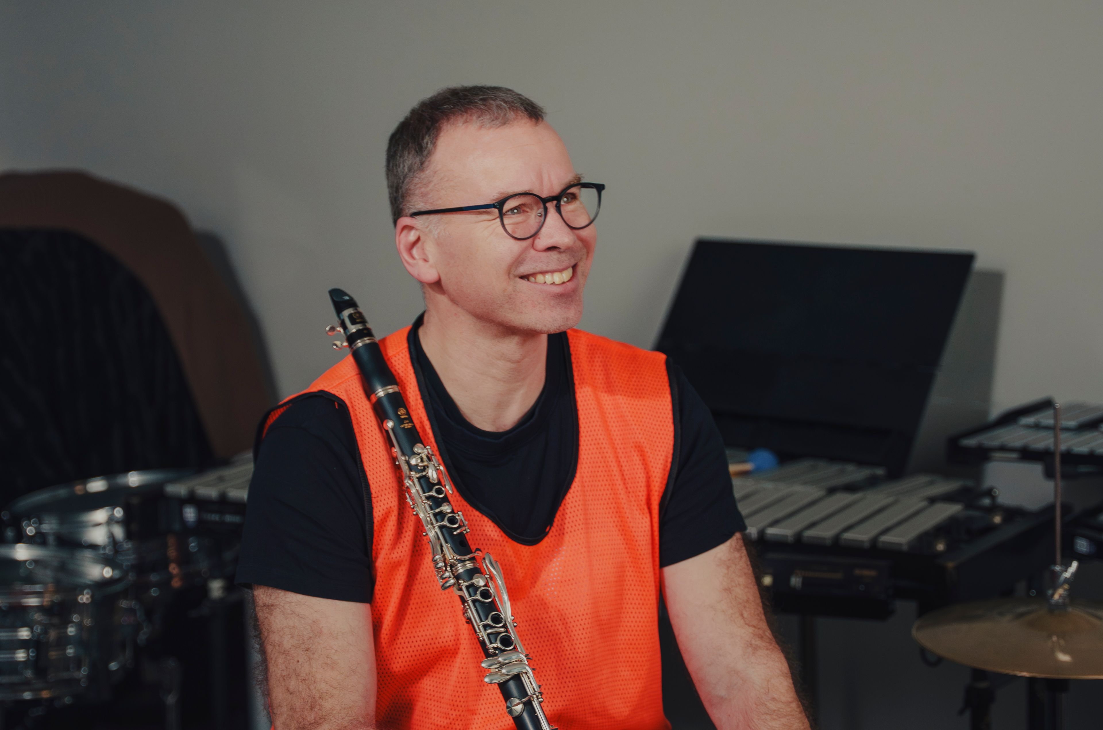 Per Christian Kittilsen smiler bredt mens han holder klarinetten foran seg, med trommer og marimba rundt seg.