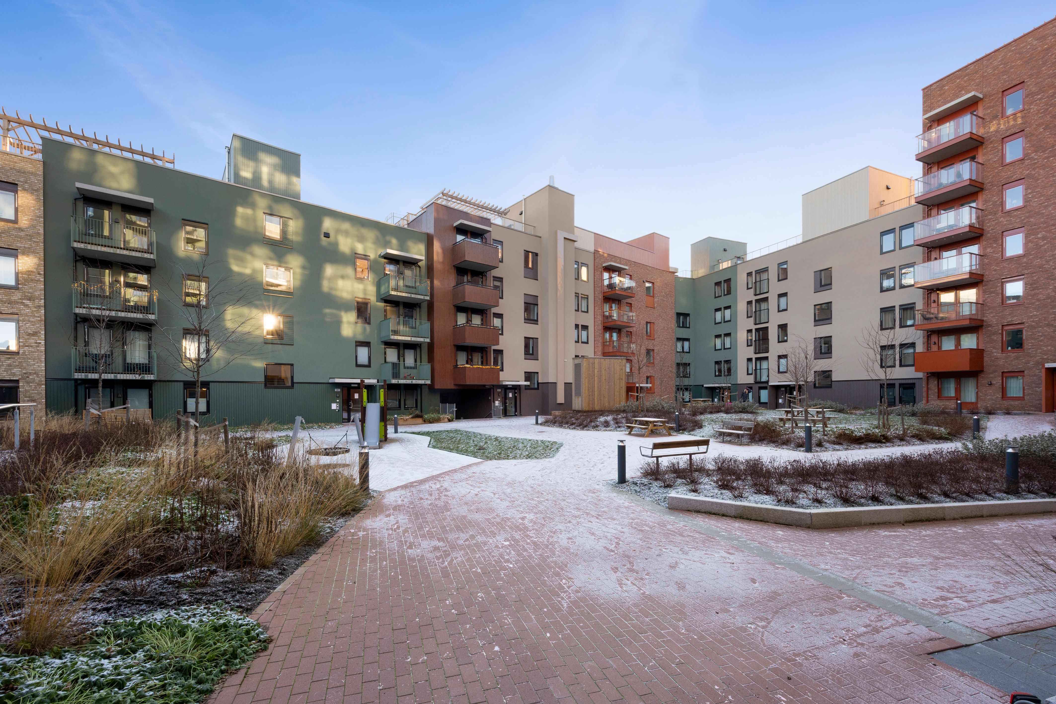 Fasade i bakgården til Vollebekk torgkvartal, med snø på bakken.