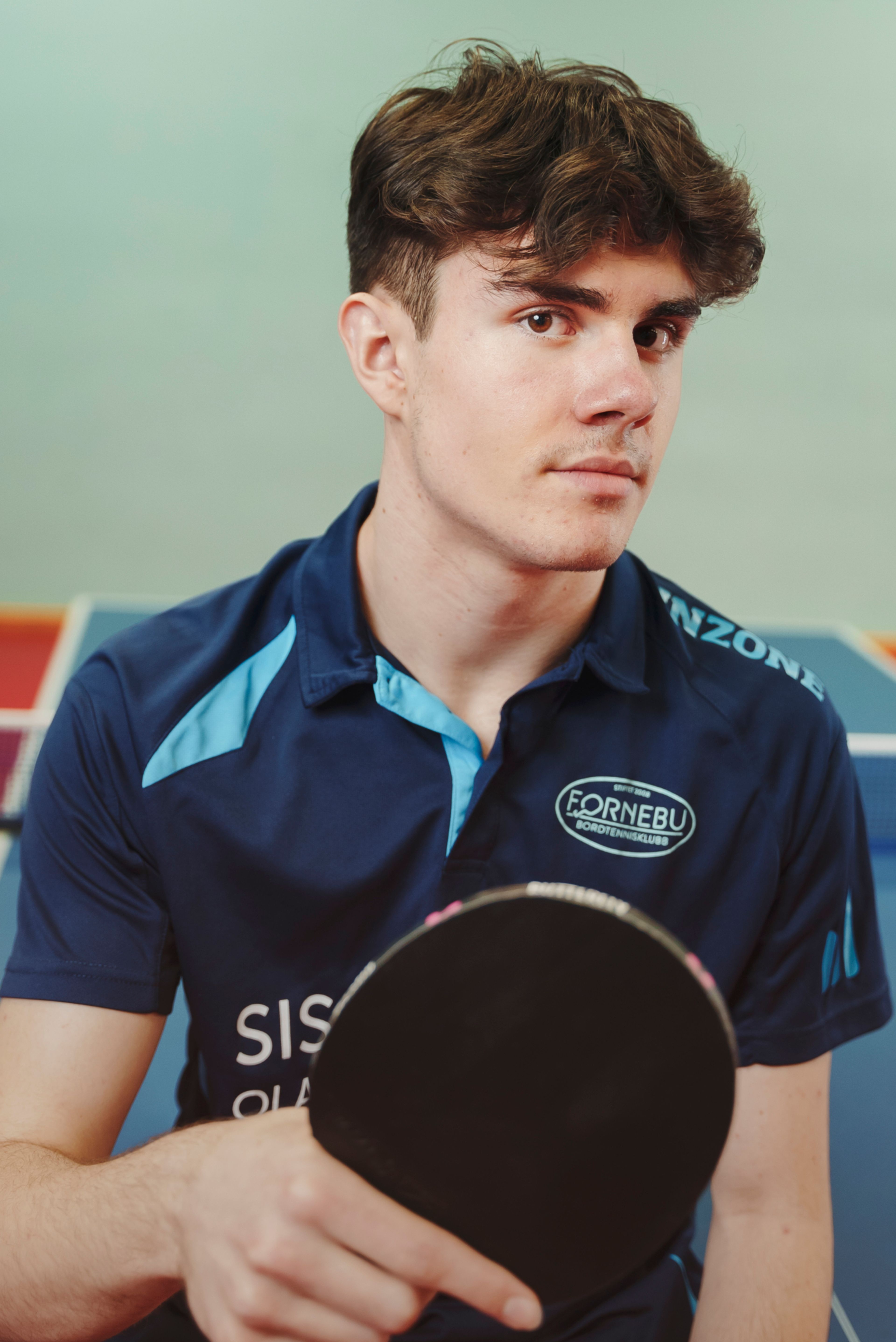 Michael har på seg FBK-drakten og holder en rackert.