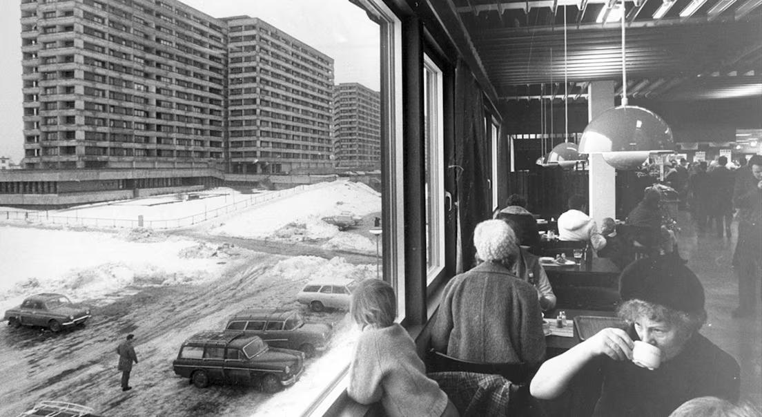 Mennesker på Tveita senter som sitter i kafeterian med utsikt til blokkene.