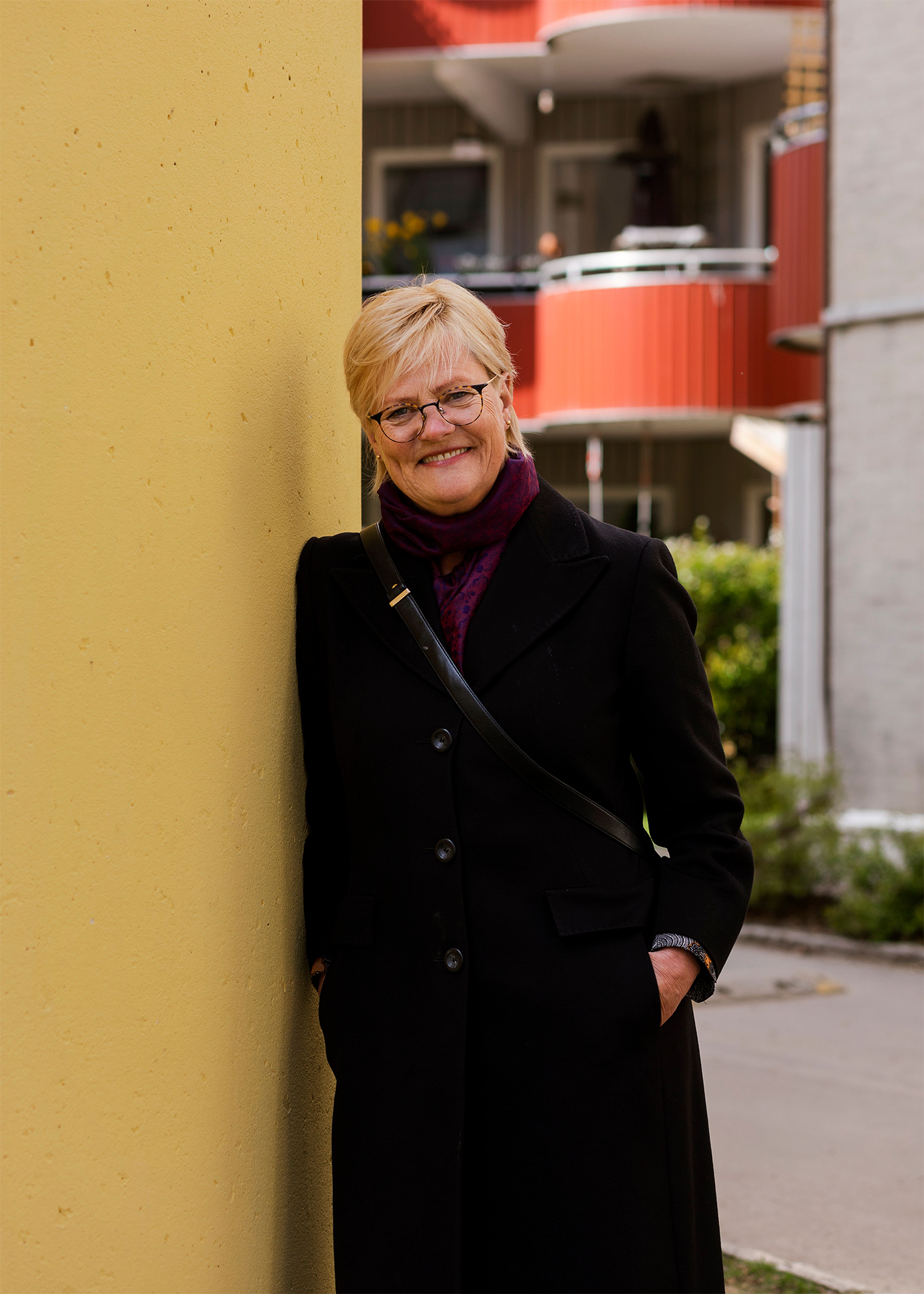 Portrett av Kristin Halvorsen i gårdsrommet i Valdresgata borettslag.