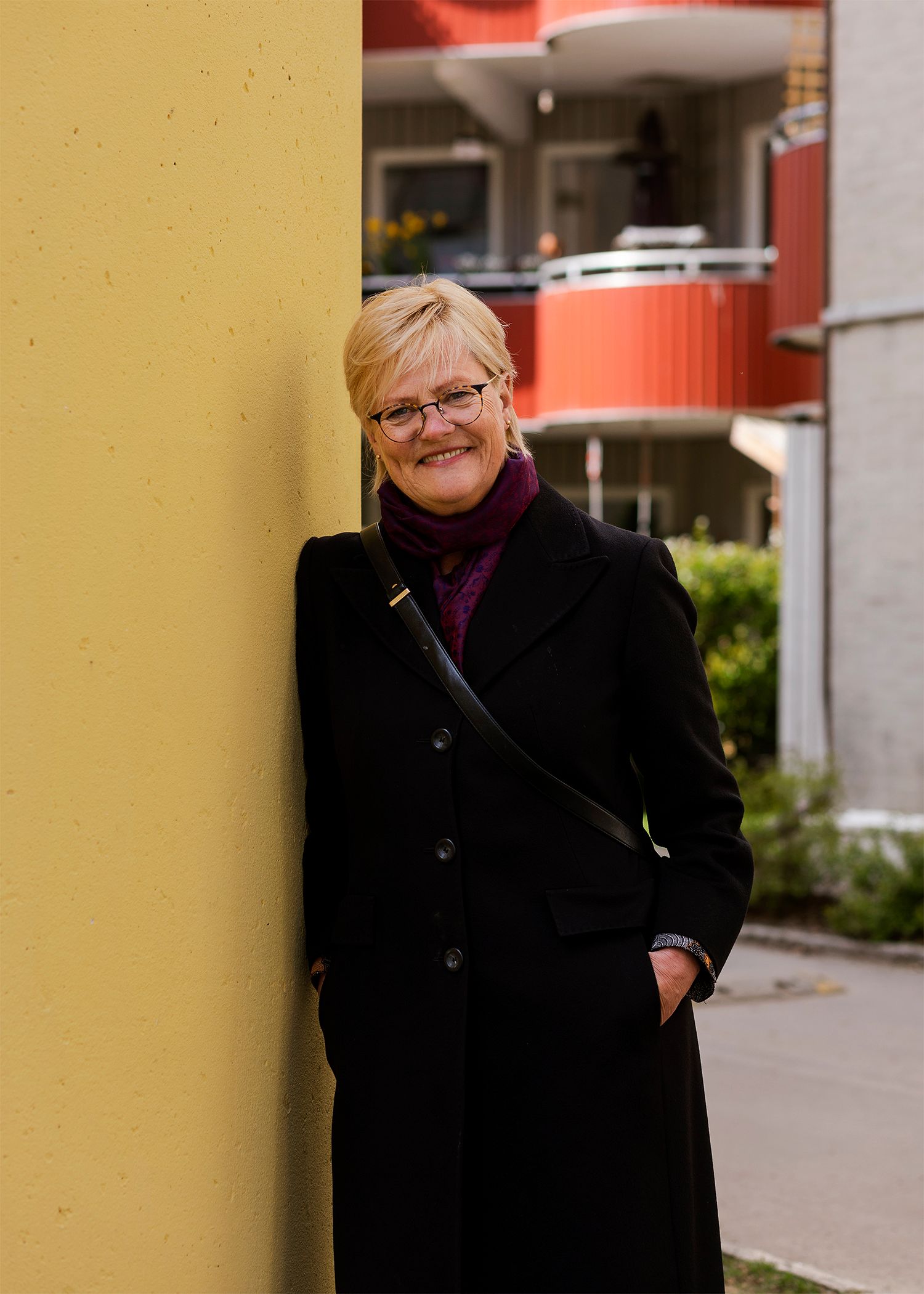 Portrett av Kristin Halvorsen i gårdsrommet i Valdresgata borettslag.