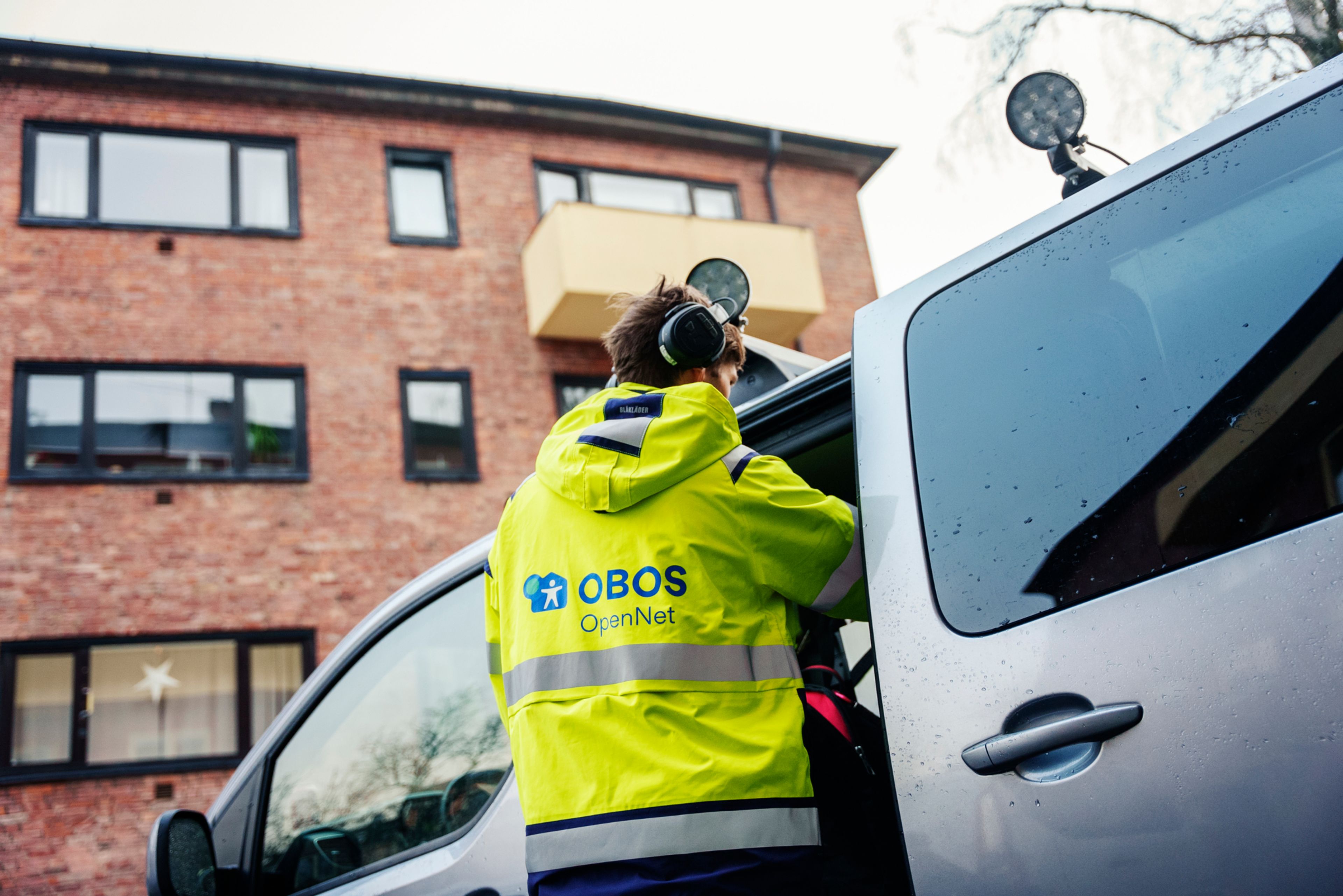 Mann i signalgul jakke med OBOS OpenNet-logo på
