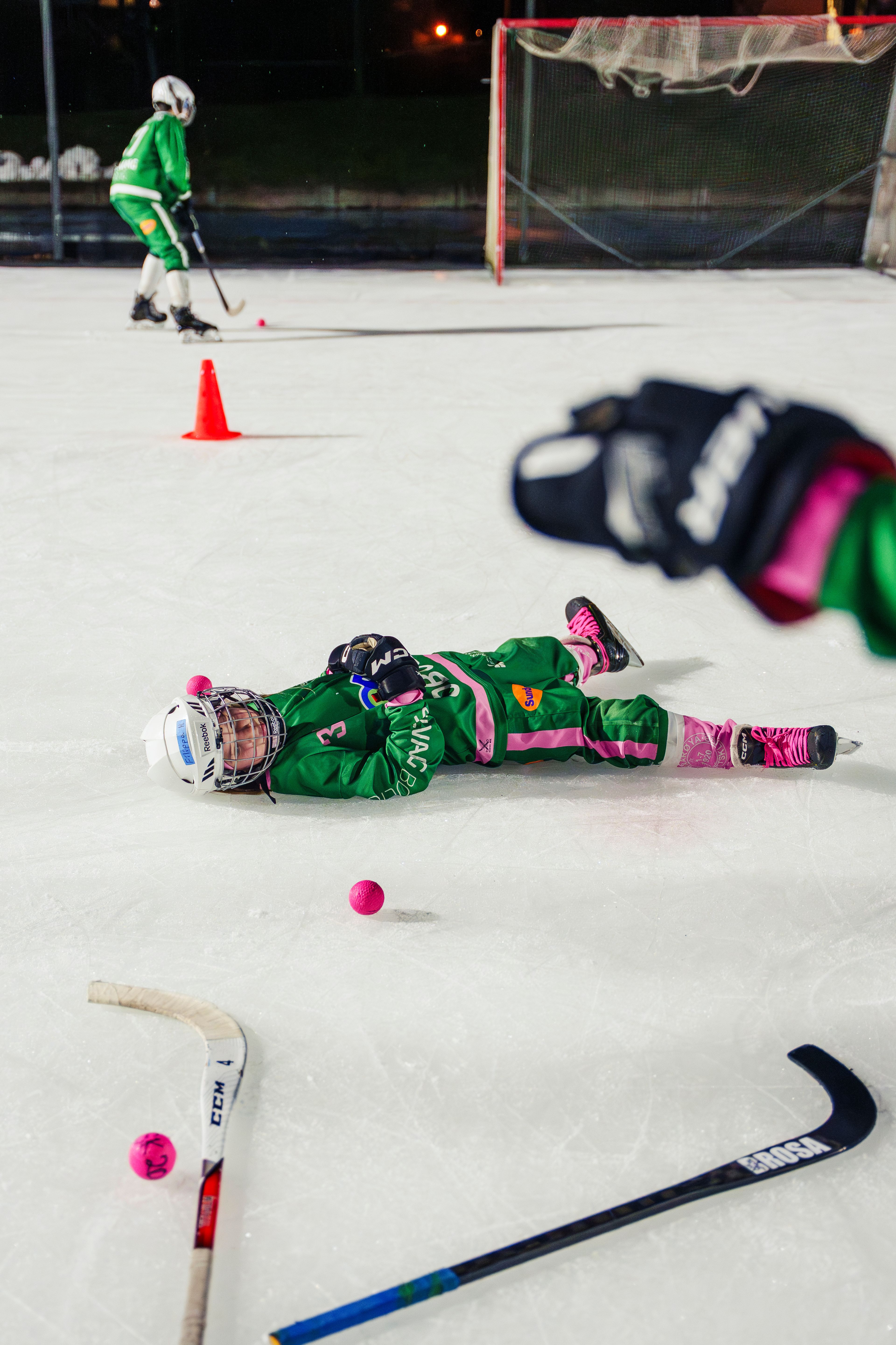 En spiller som ligger rett ut på isen.