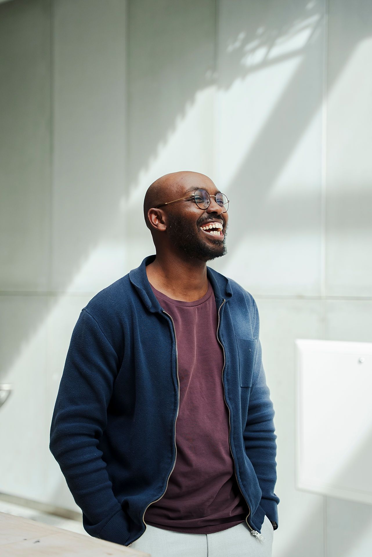 Bilde av Bishar Ali som har på seg en blå jakke og en lilla t-skjorte. Han holder hendene i lommen og smiler bredt.