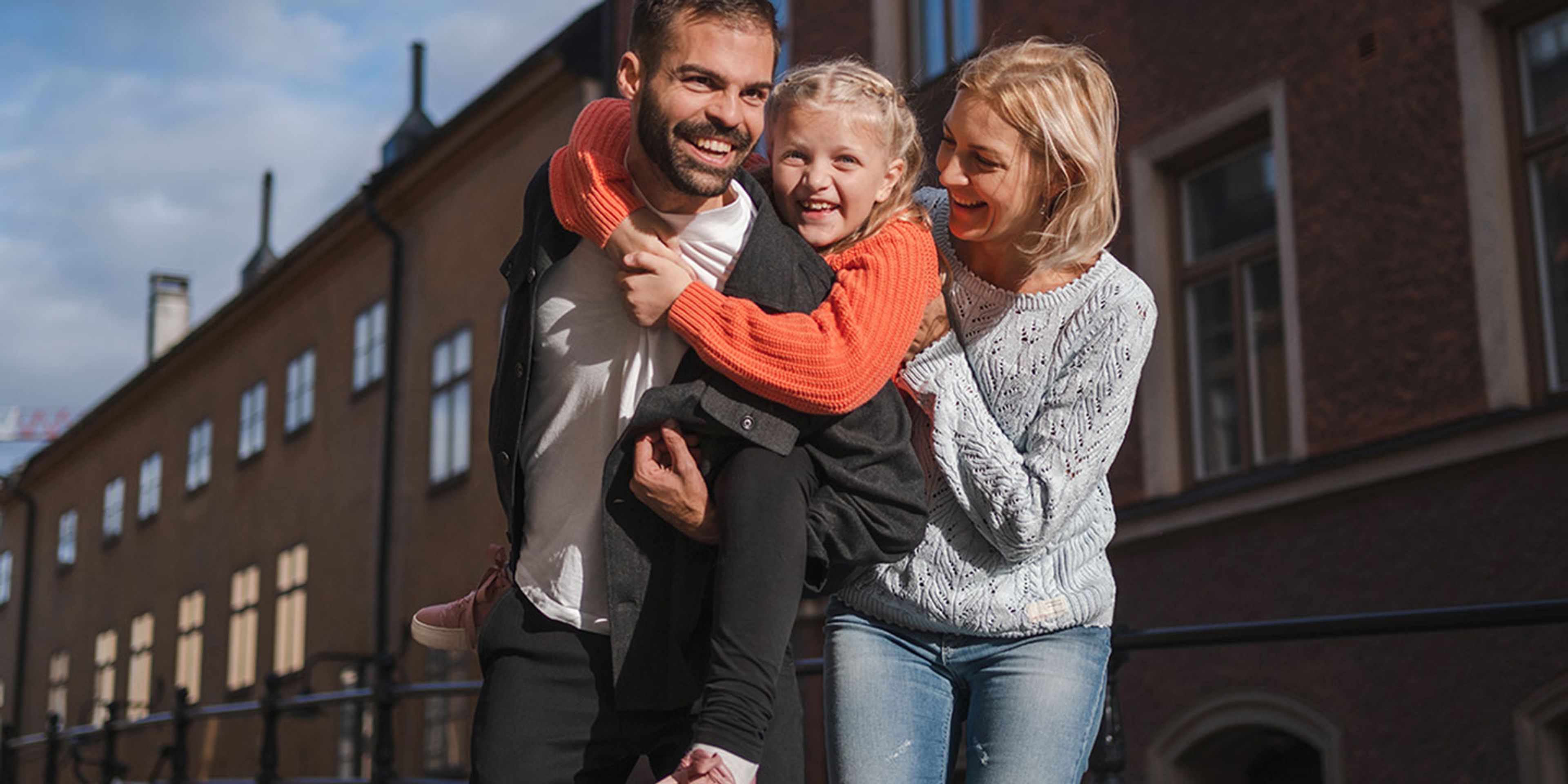 Familj med dottern på ryggen på sin pappa
