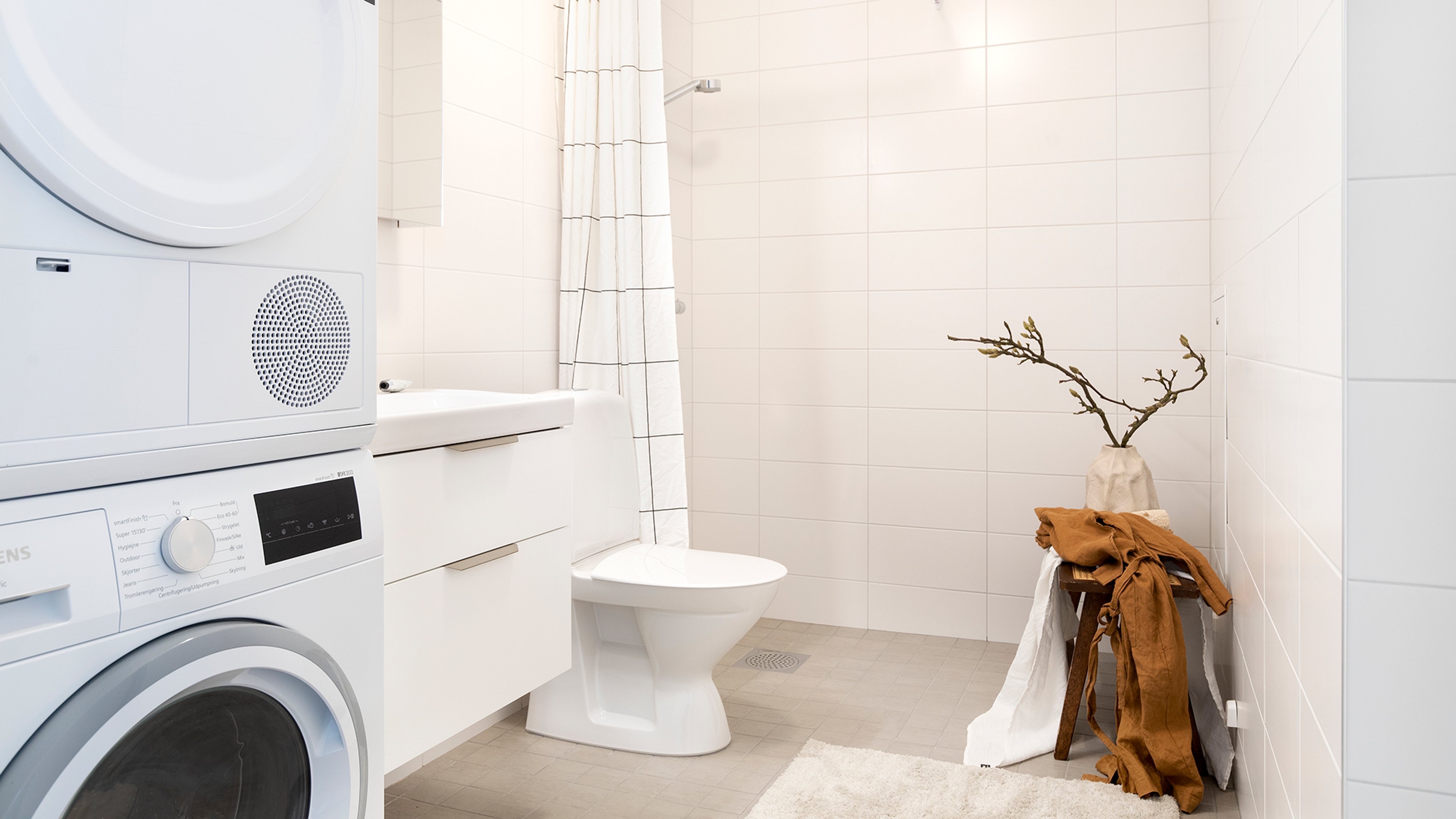 Rymligt badrum med tvättmaskin och torktumlare