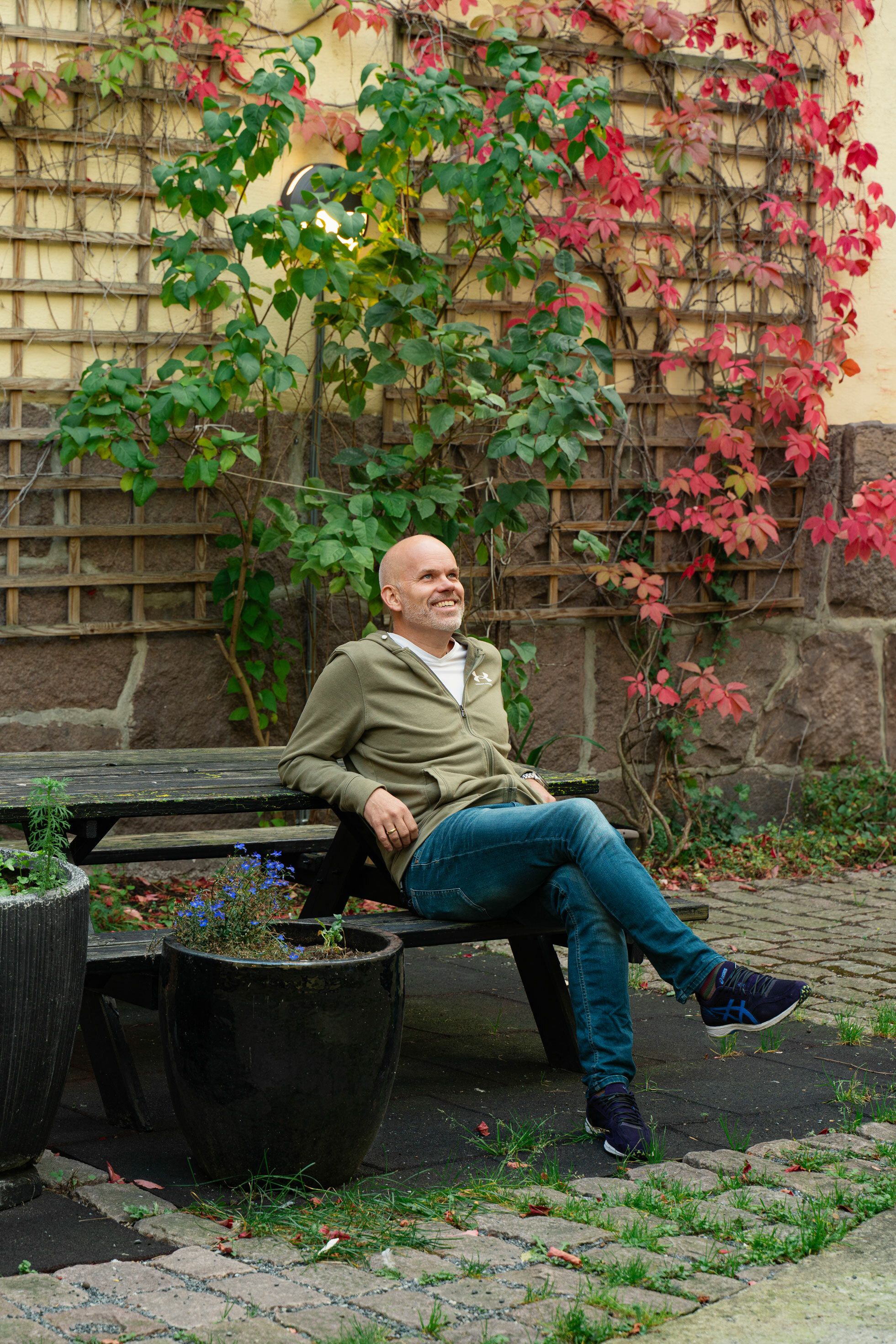 Christoffer Stange sitter på en benk i bakgården i Pilestredet 30.