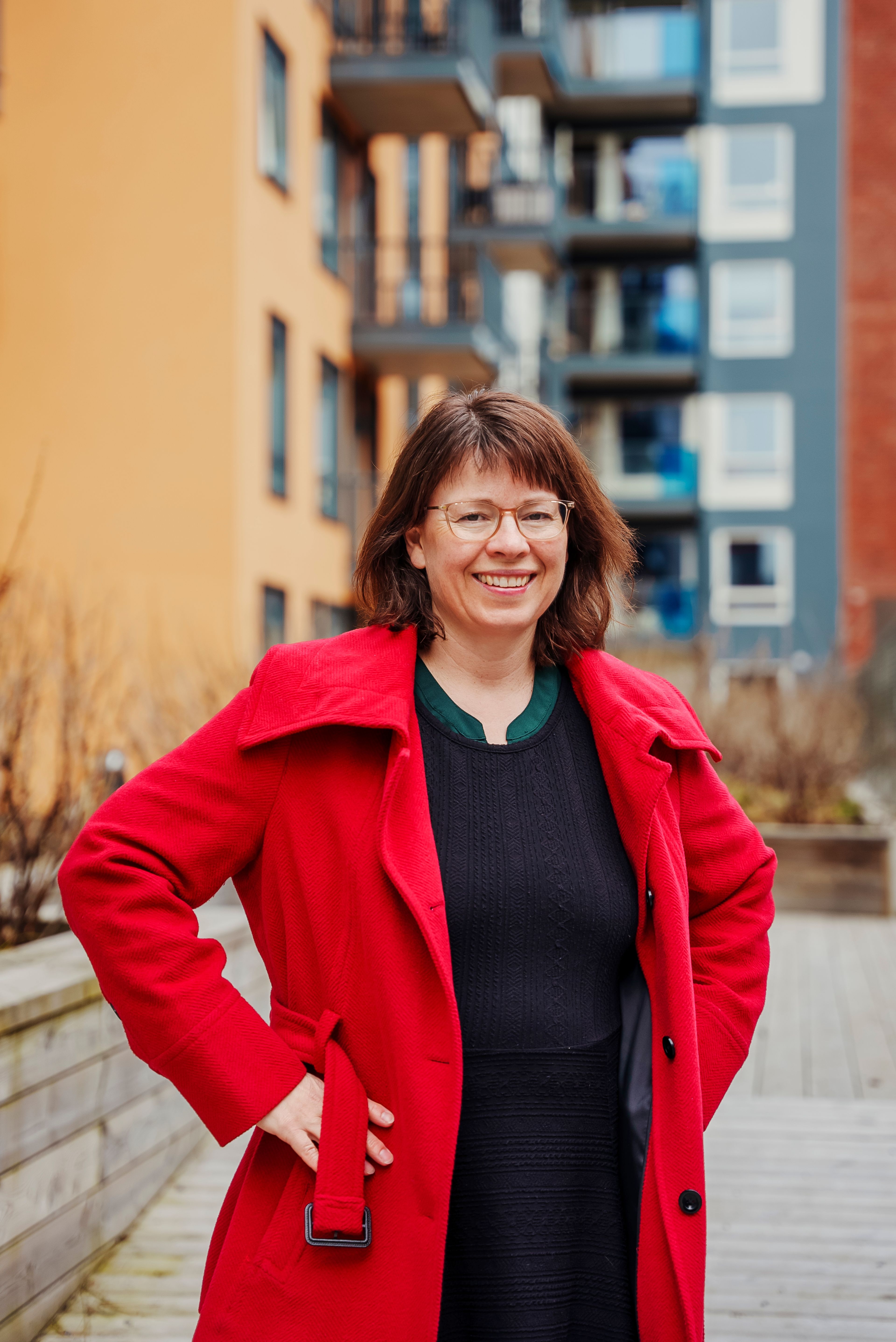 Hanne Løvbrøtte i OBOS står utenfor et boligbygg og smiler.