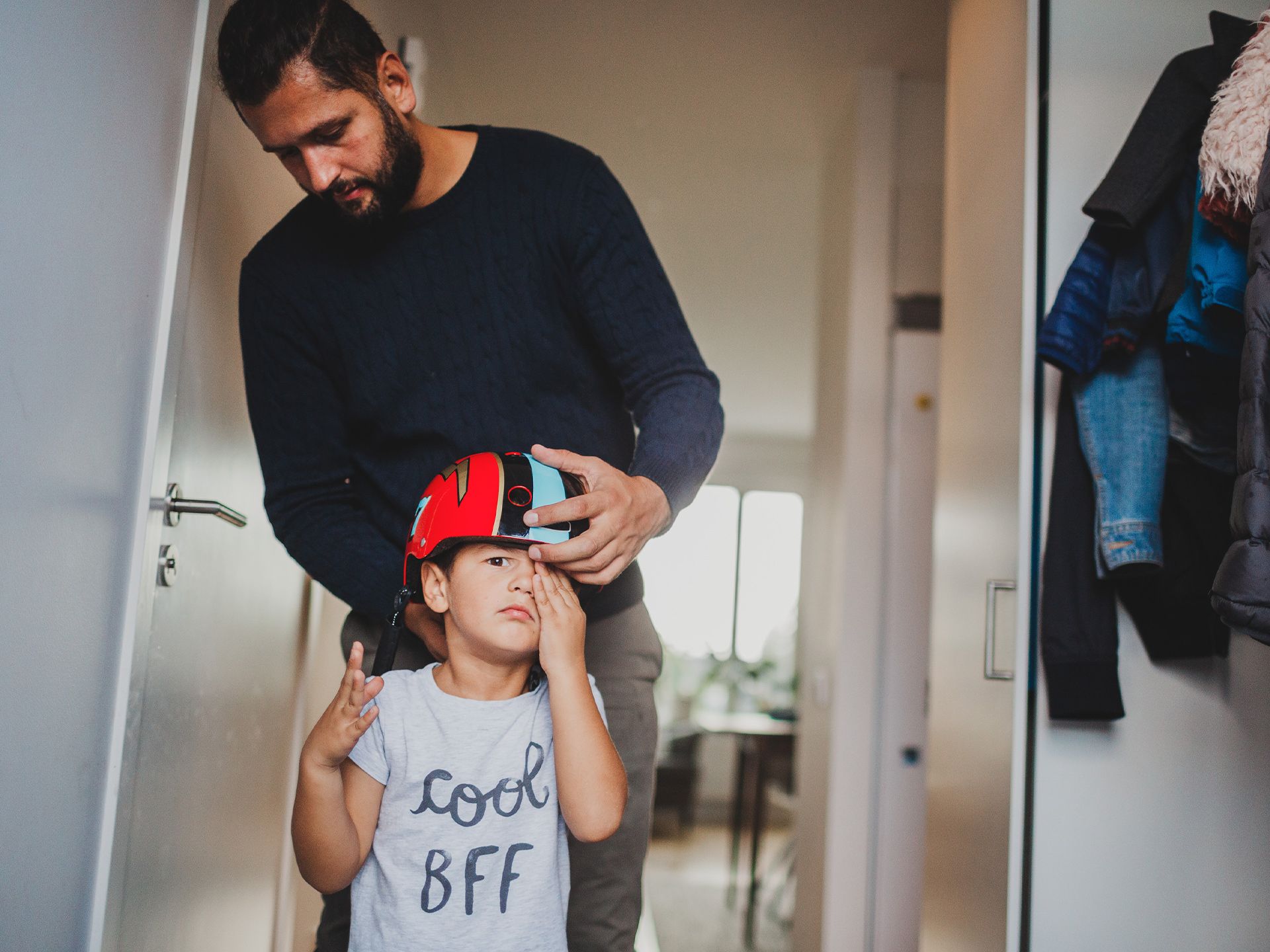 En man som hjälper ett barn att ta på sig en hjälm