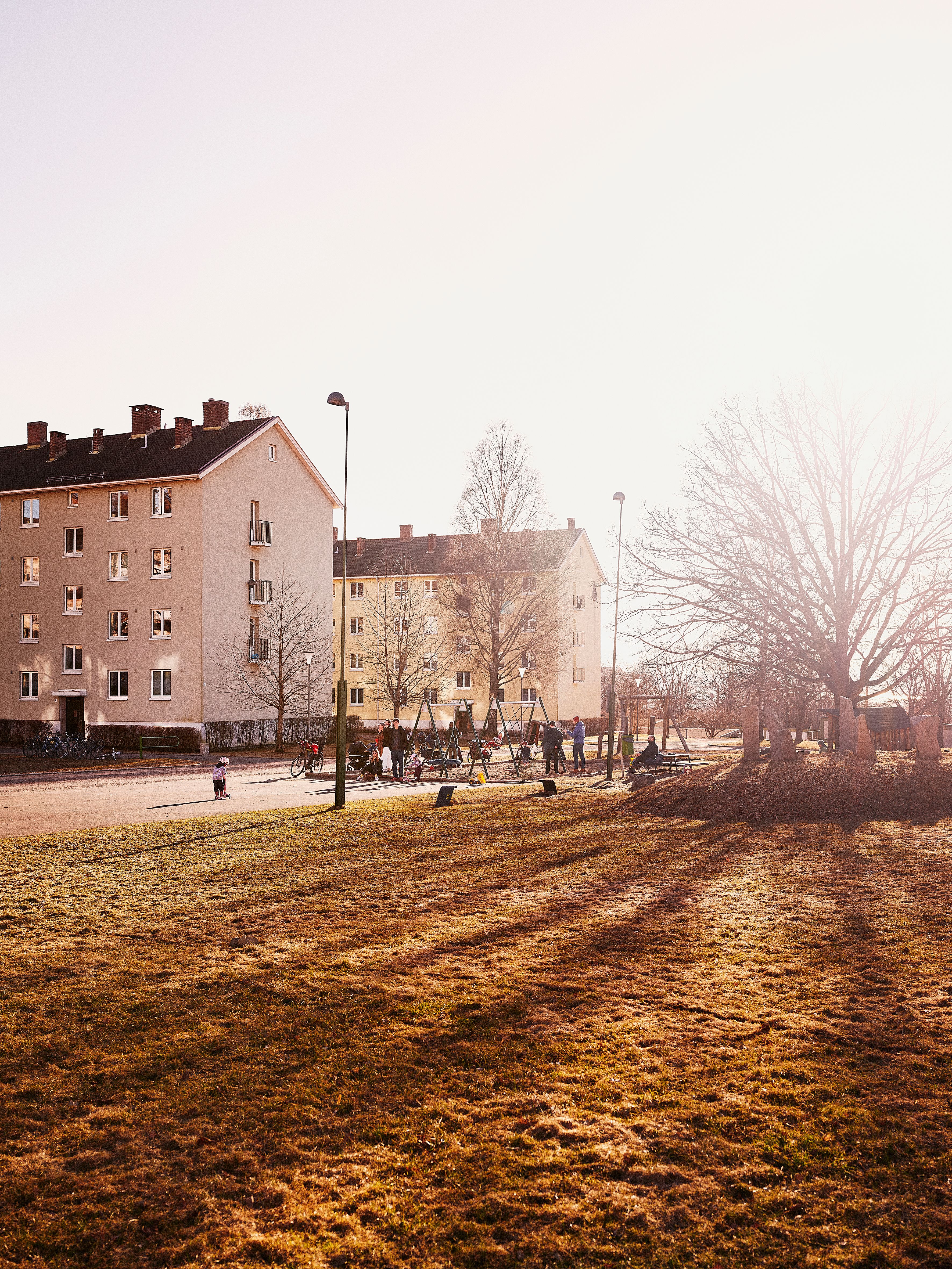 Et bilde av to boligblokker som står ved siden av hverandre. I forkant er det en stor gresslette.