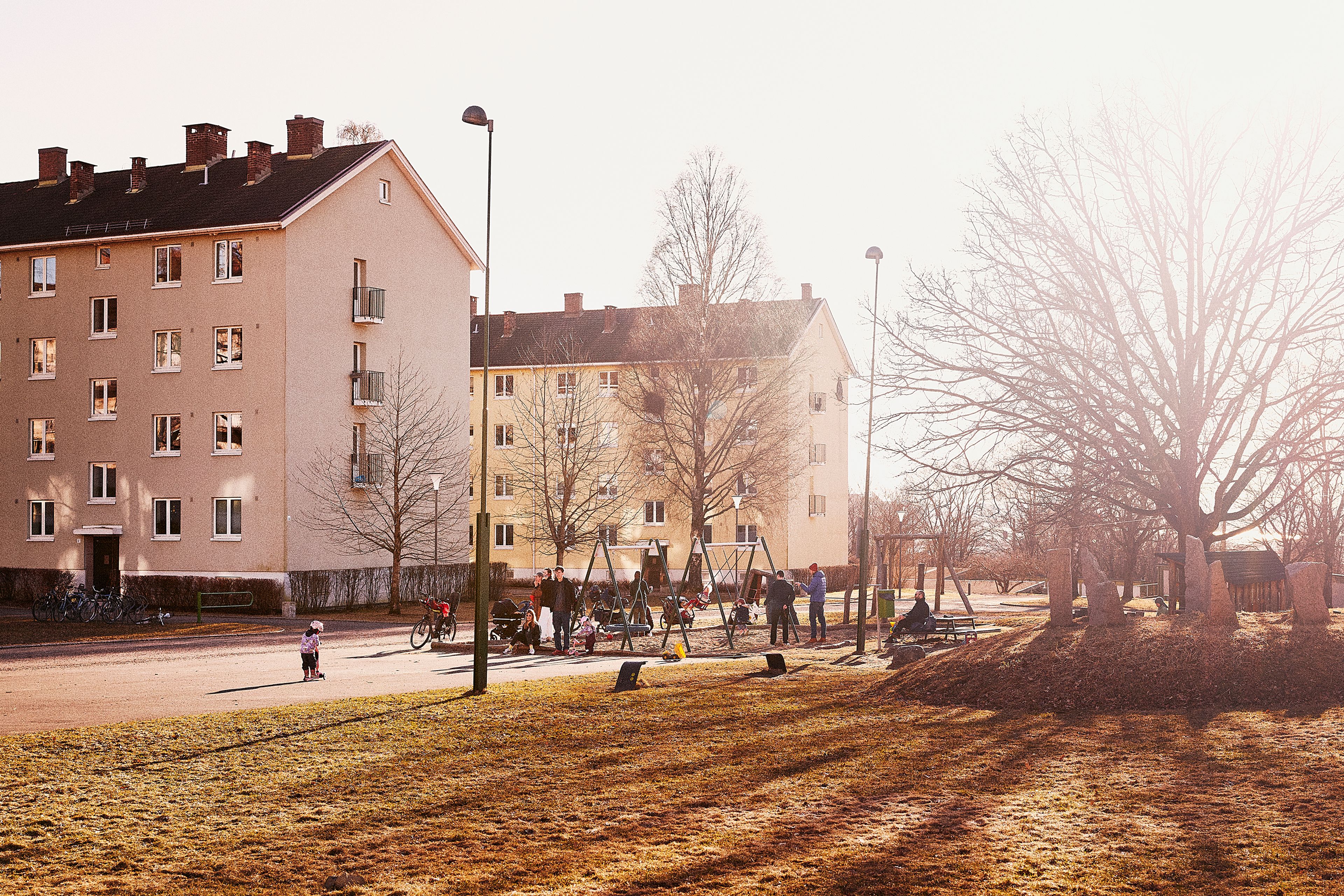 Et bilde av to boligblokker som står ved siden av hverandre. I forkant er det en stor gresslette.